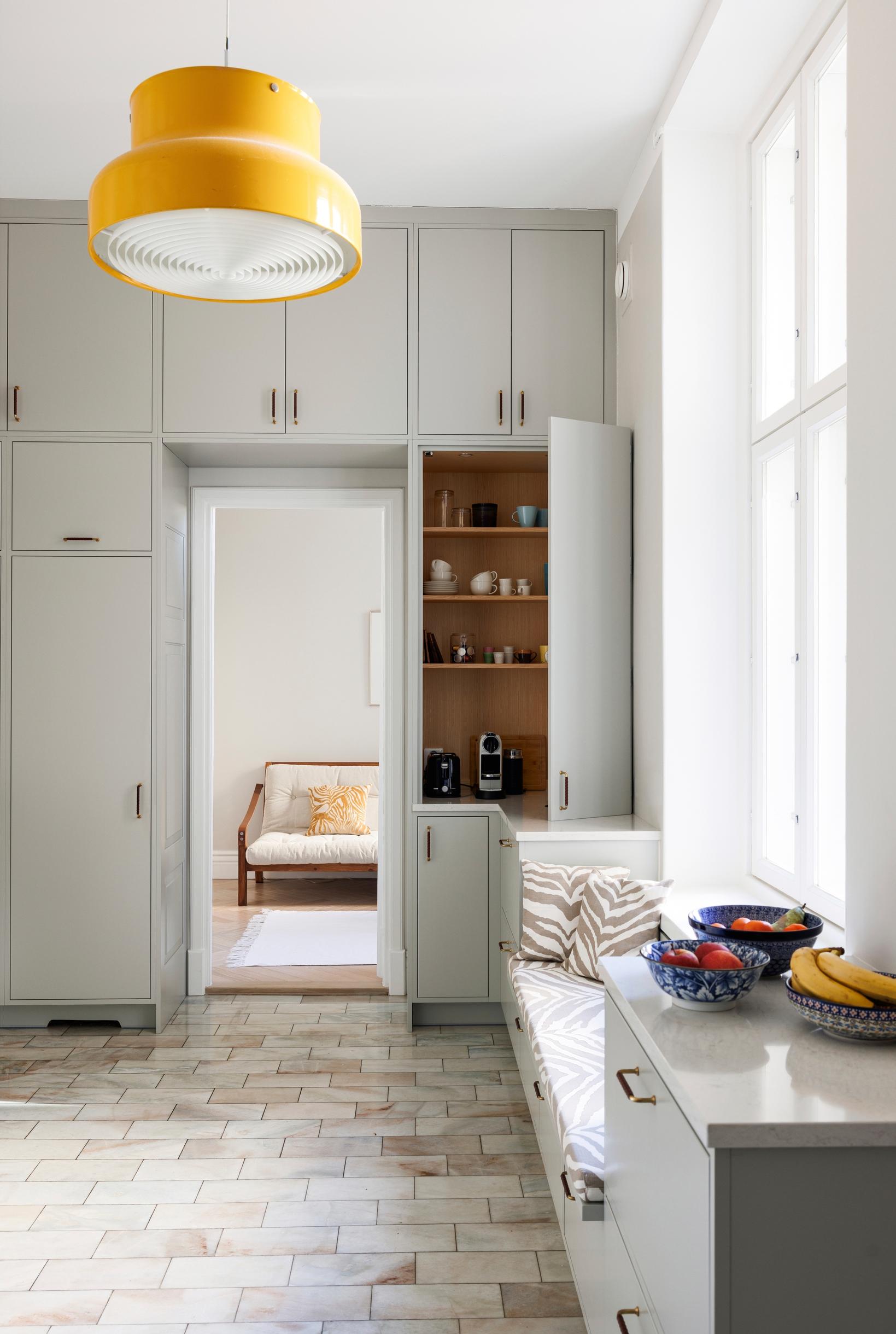 The kitchen has a marble floor, light built-in cabinetry, and a wooden interior in the breakfast cabinet.