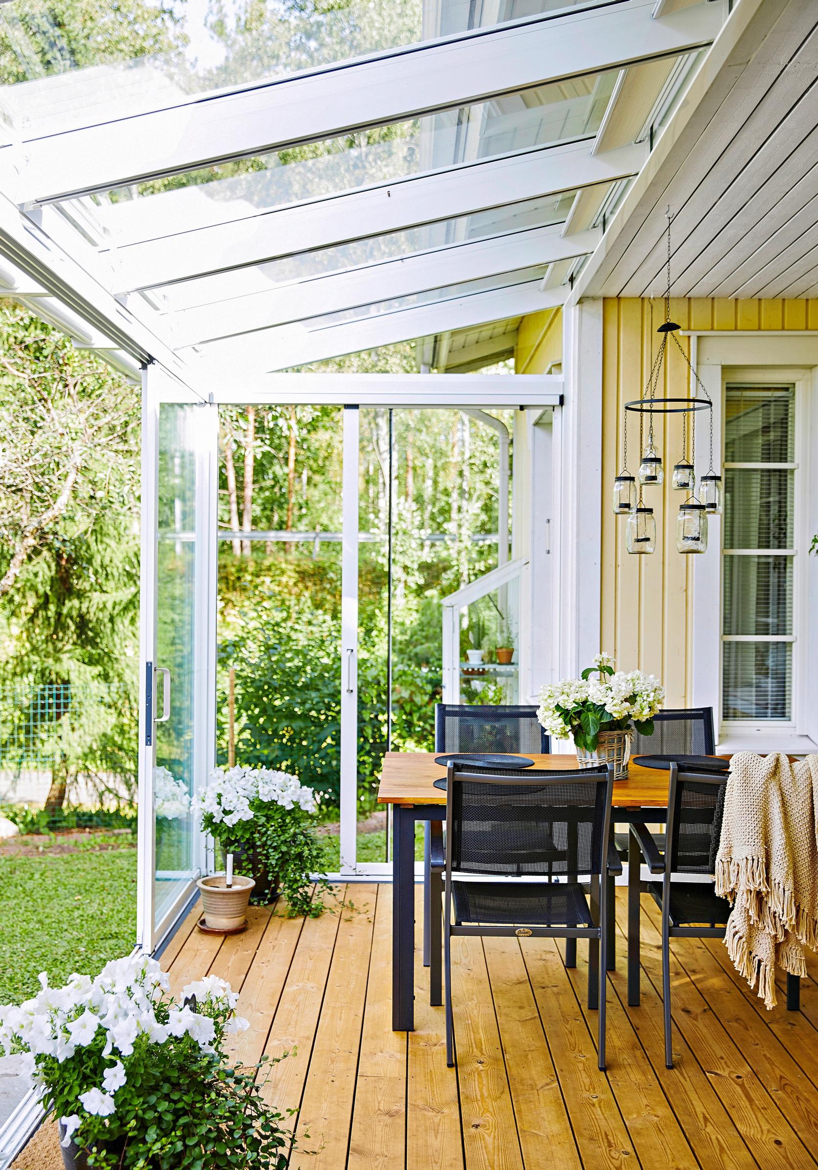 A glass-enclosed patio on the side of the house.