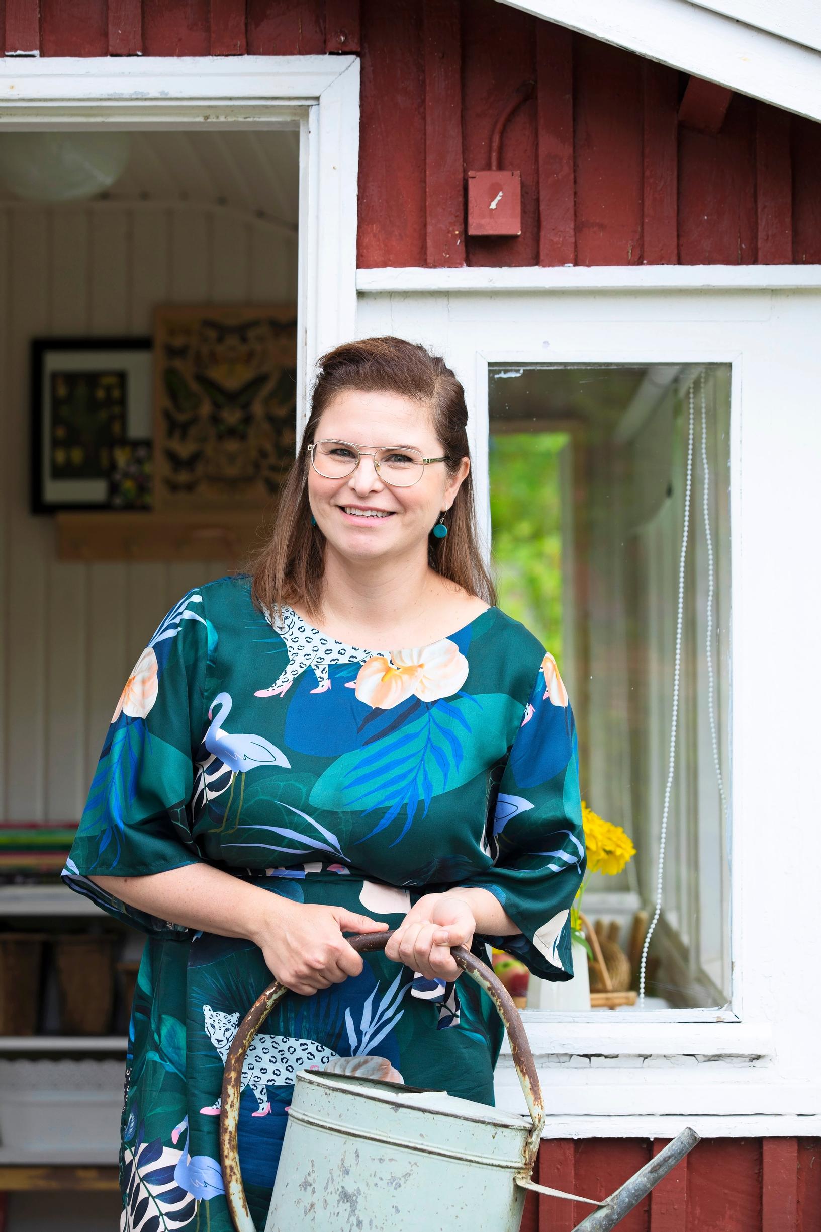 Woman on a porch holding a watering can
