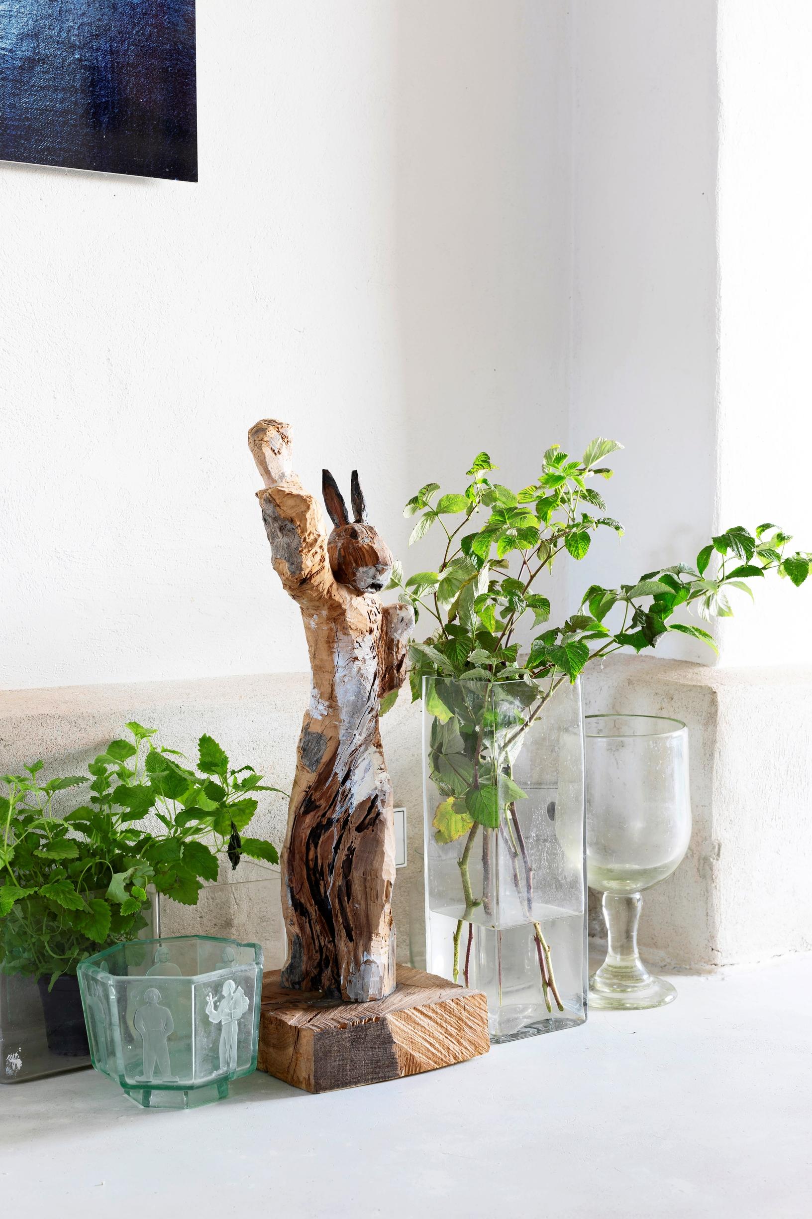 a rabbit sculpture, glass objects, and plants