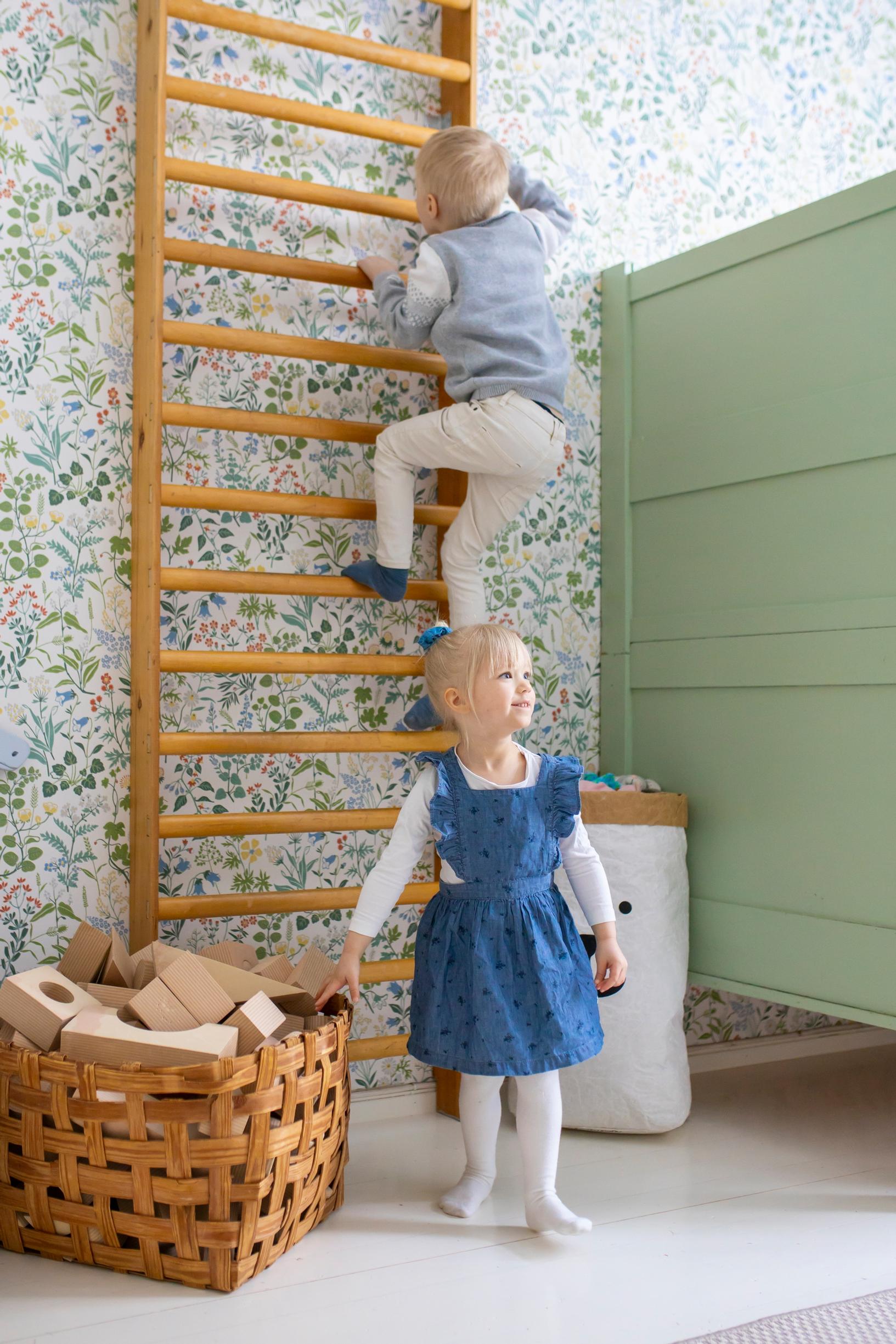 The children climbing on the wall bars.