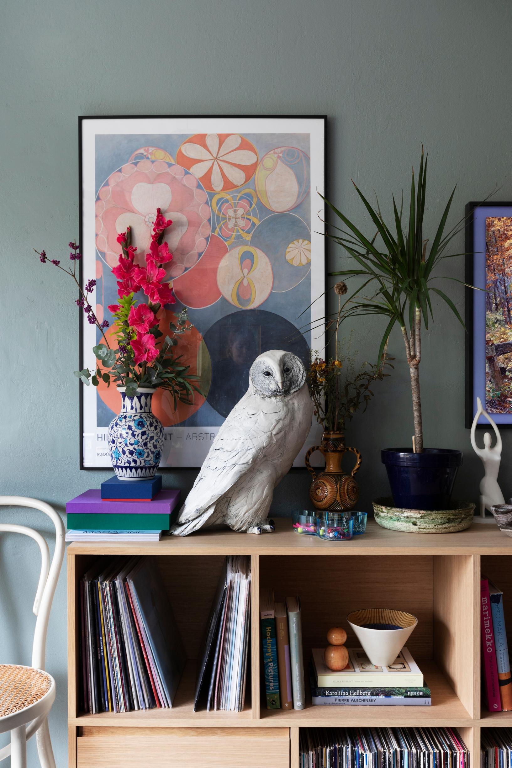 A shelf arrangement featuring Lotta Mattila’s dramatic owl sculpture