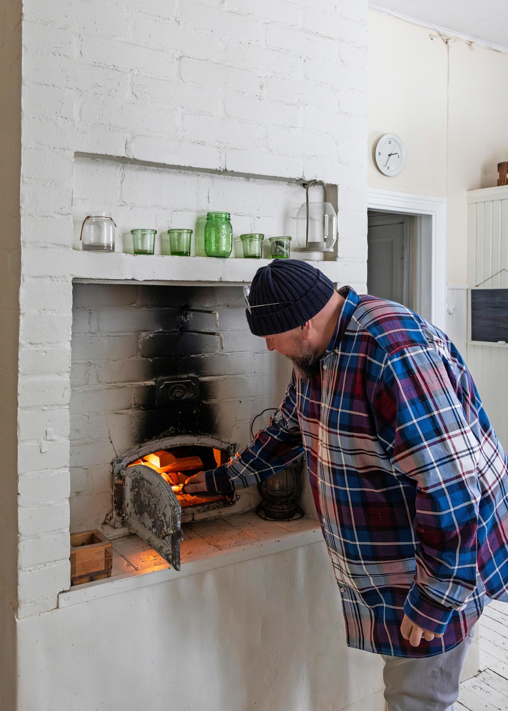 Kimi Henriksson lighting a fire in the oven