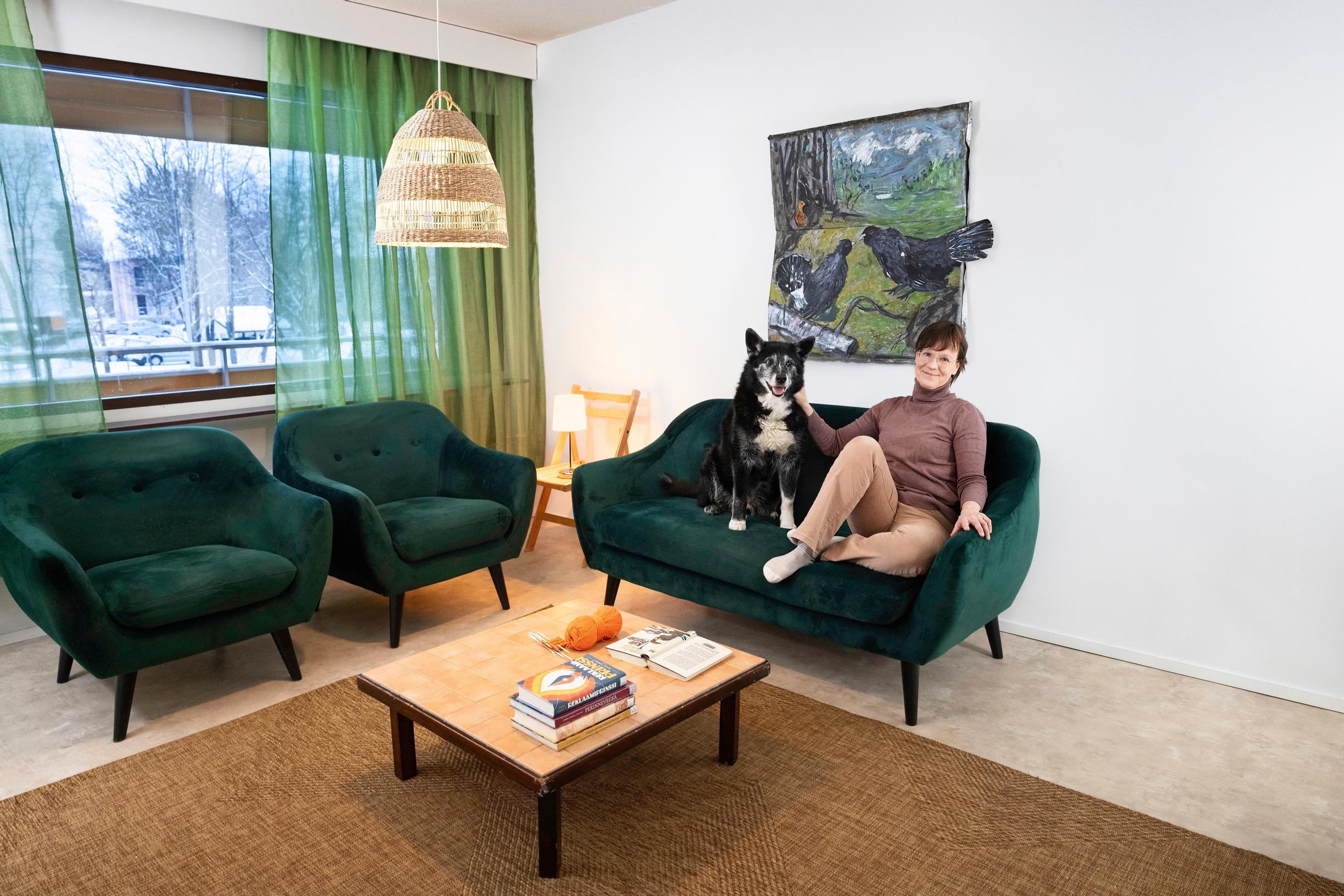 a woman sitting on the couch with a dog in the living room
