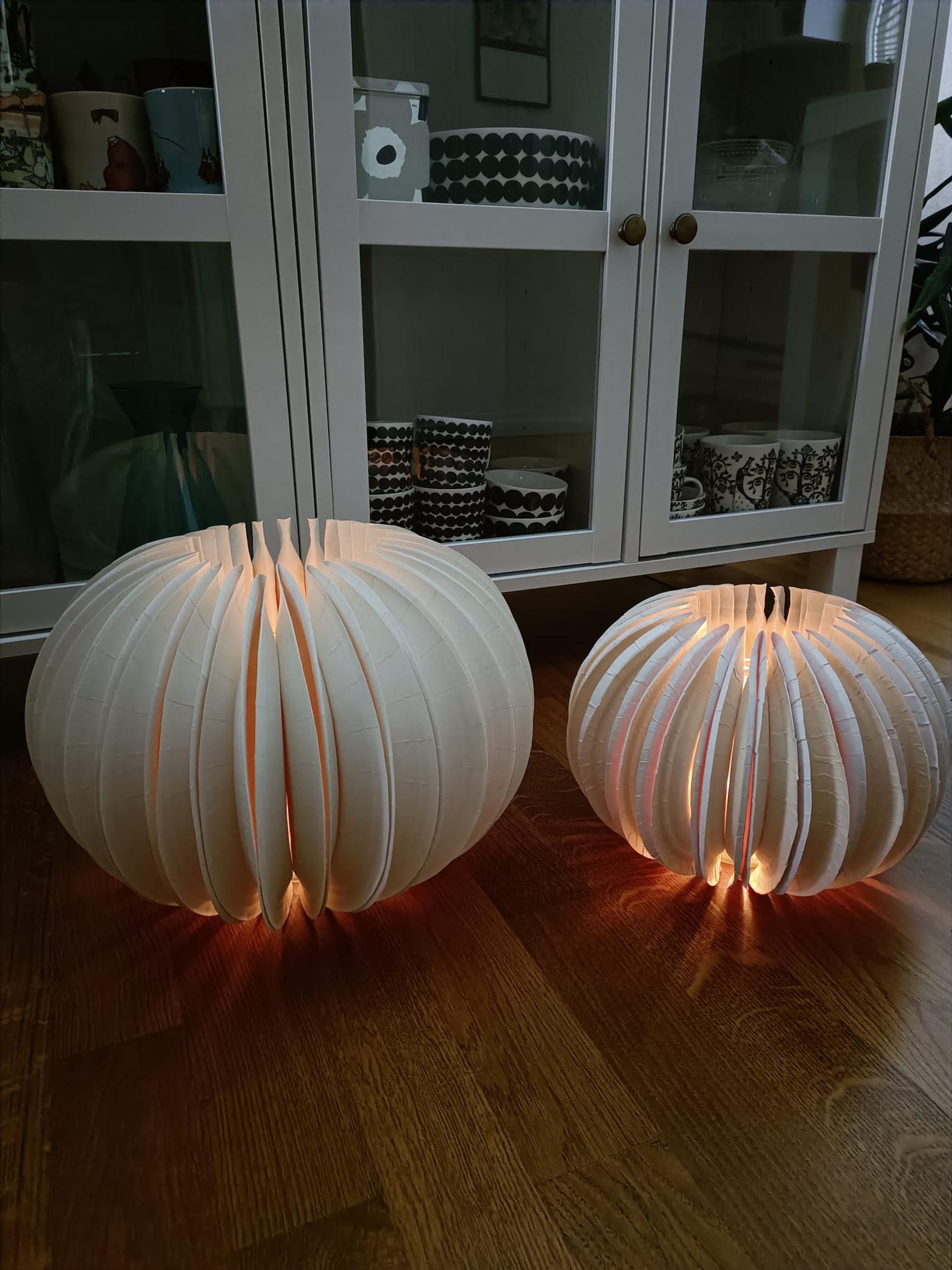 Two lanterns made from paper plates on the floor