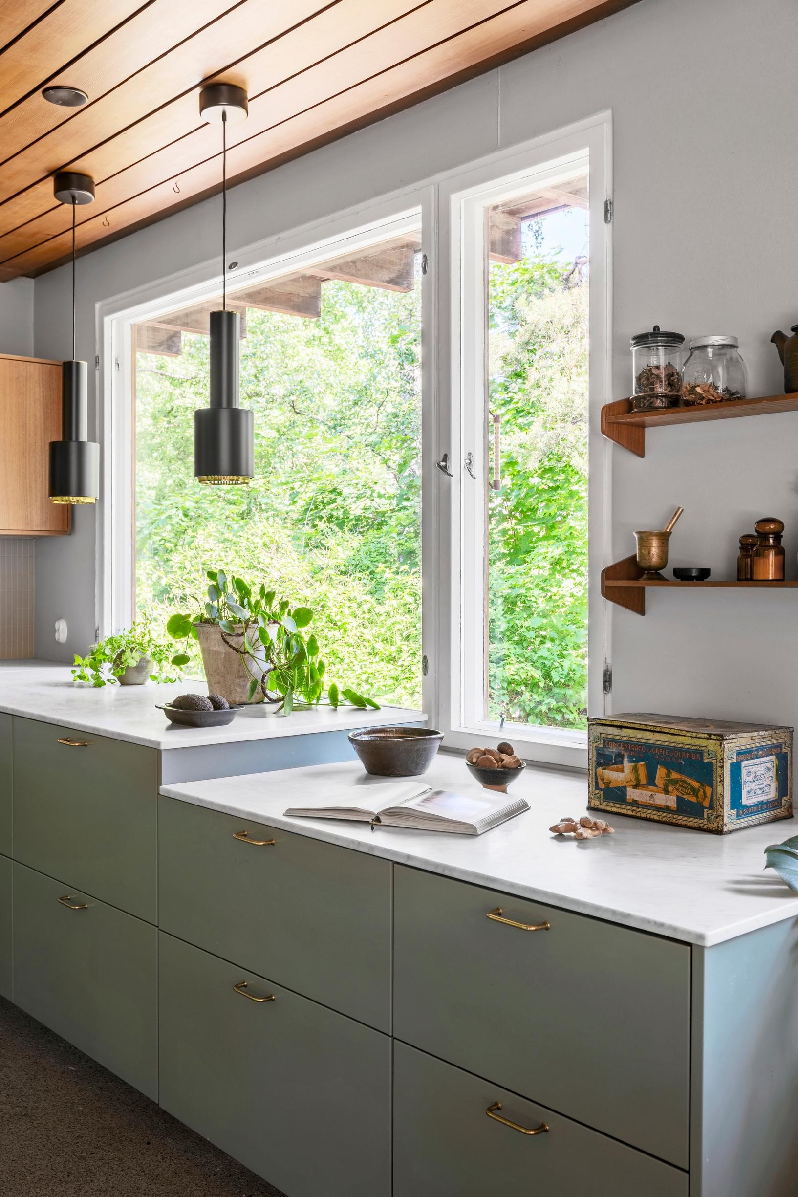 Artek’s A110 pendant lamps in front of the kitchen window