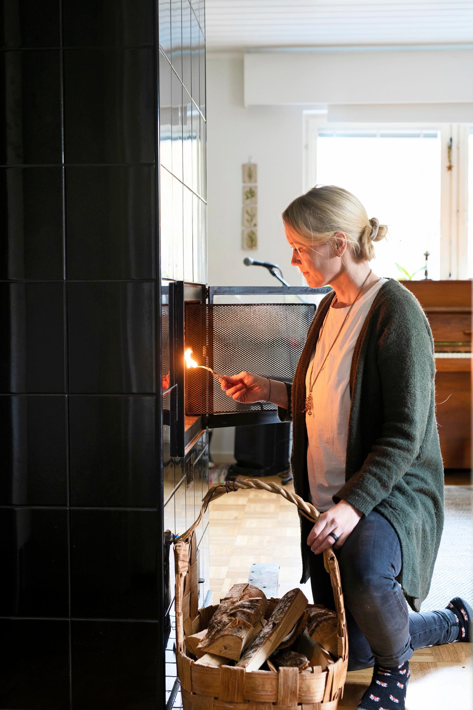 woman lighting a fire in a fireplace