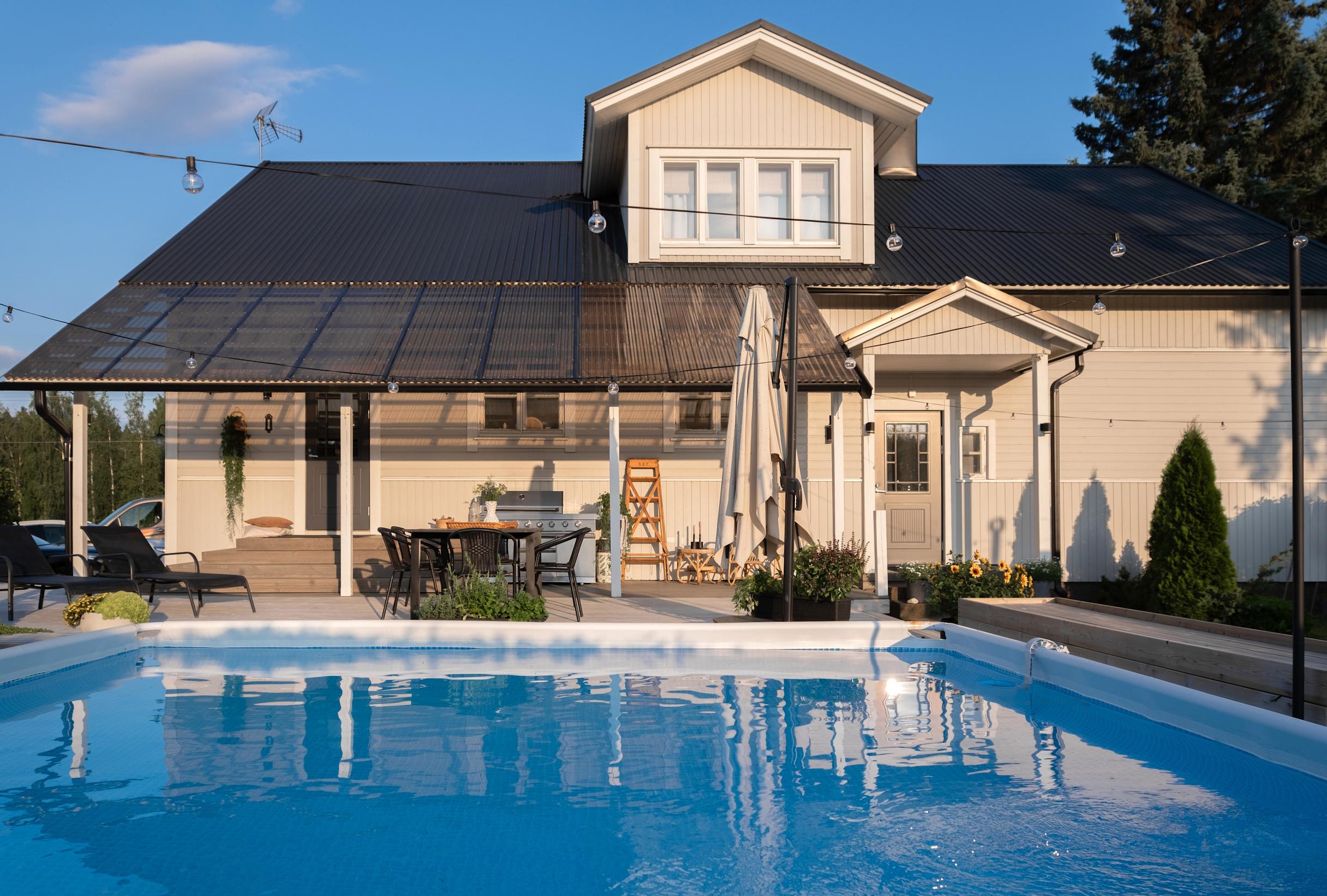 A swimming pool sits in front of the single-family home’s deck