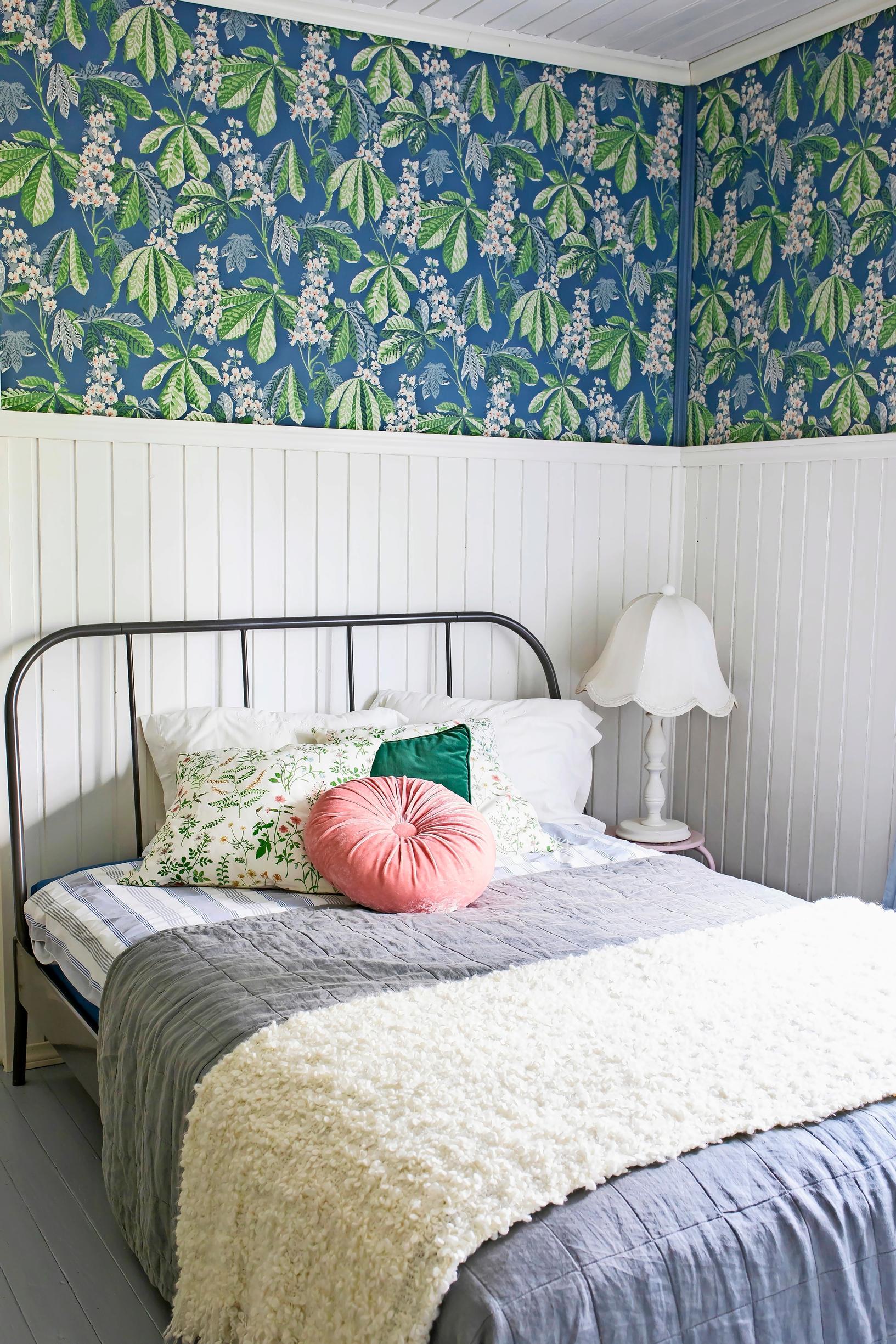 Guest room: White wainscoting and a colorful wallpapered wall