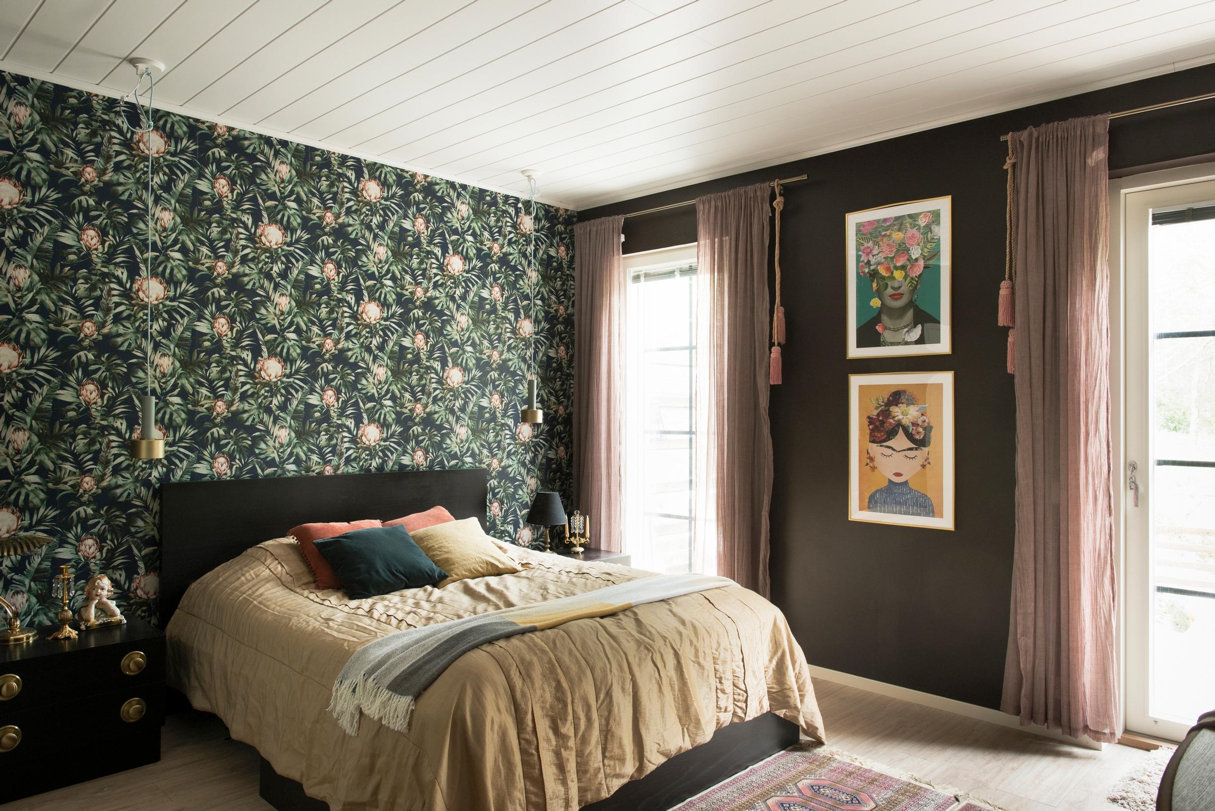 A dark window wall and delicate sheer curtains in a bedroom