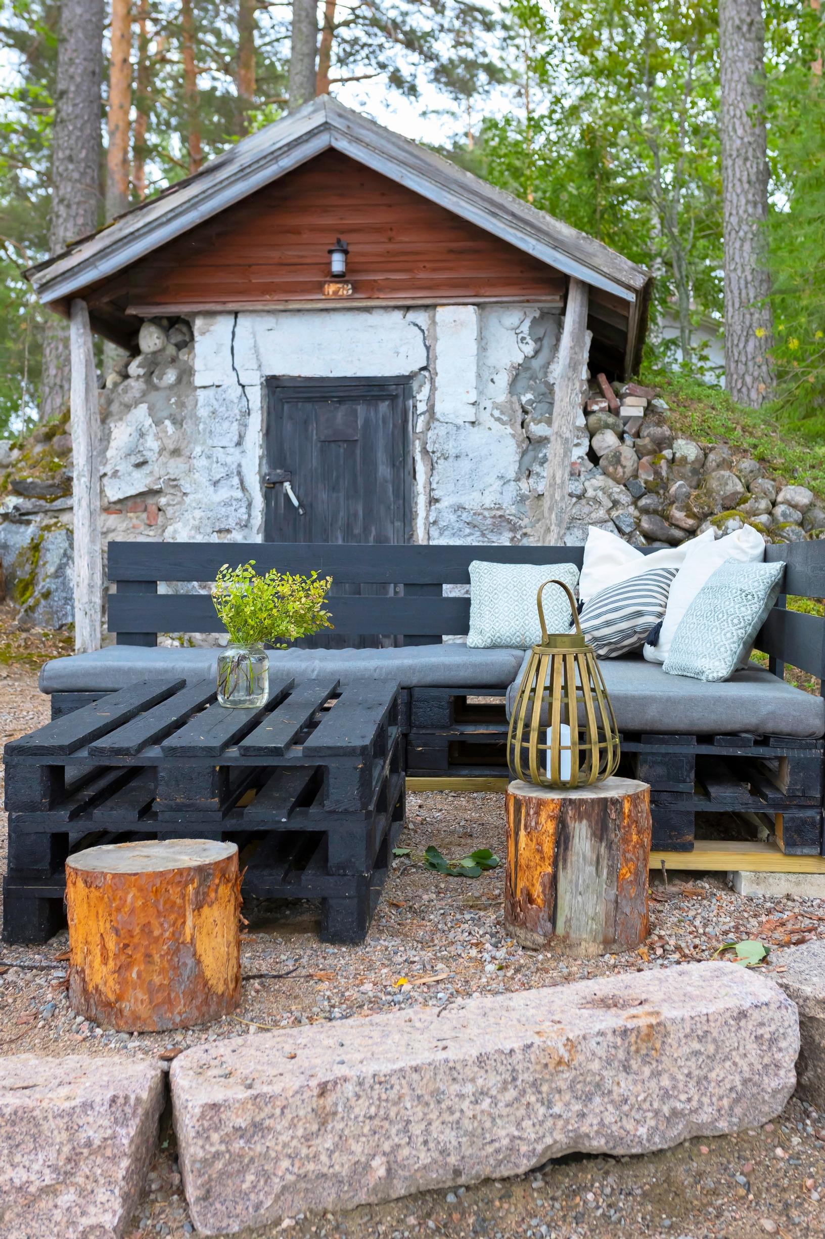 Black sofa set made from Euro-pallets in front of the root cellar.