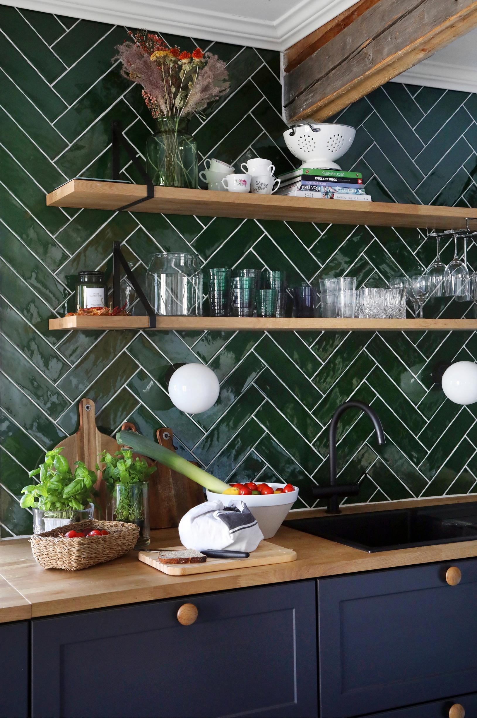 Green tiles as the backdrop of a Shaker-style kitchen