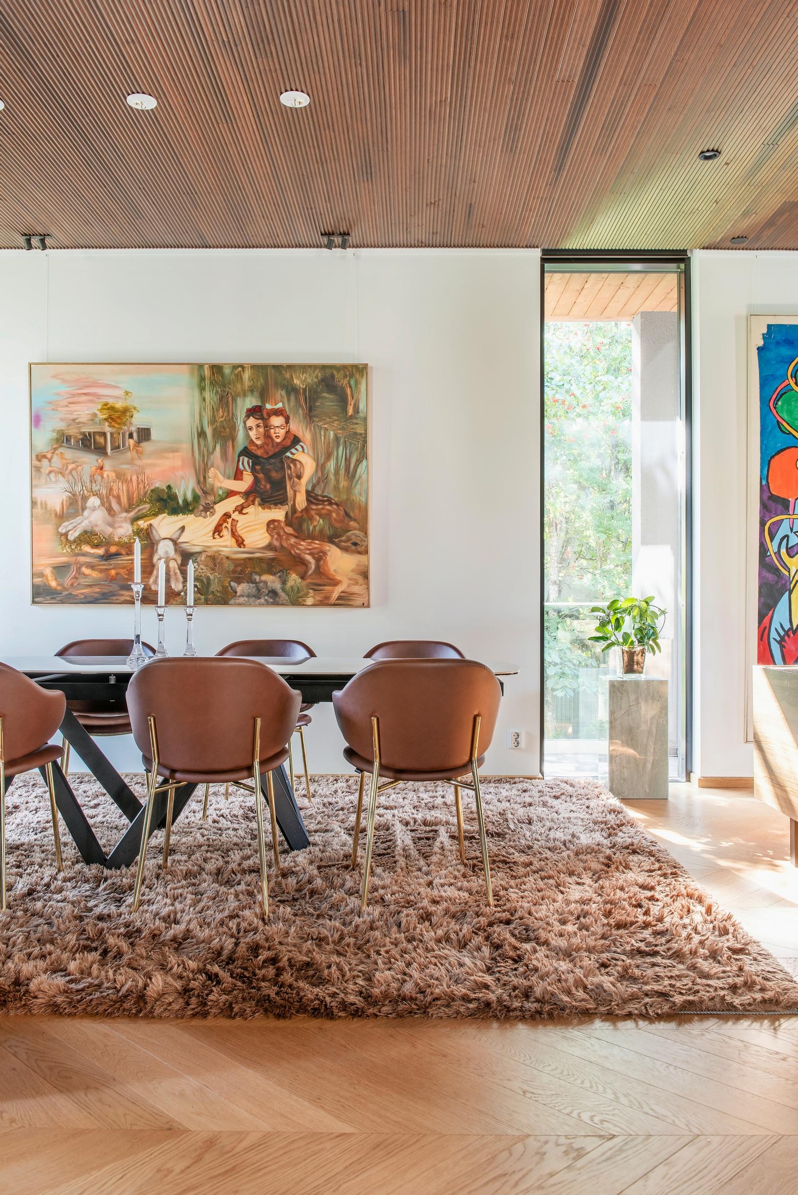 A large dining area next to the living space, with artwork and a plush rug