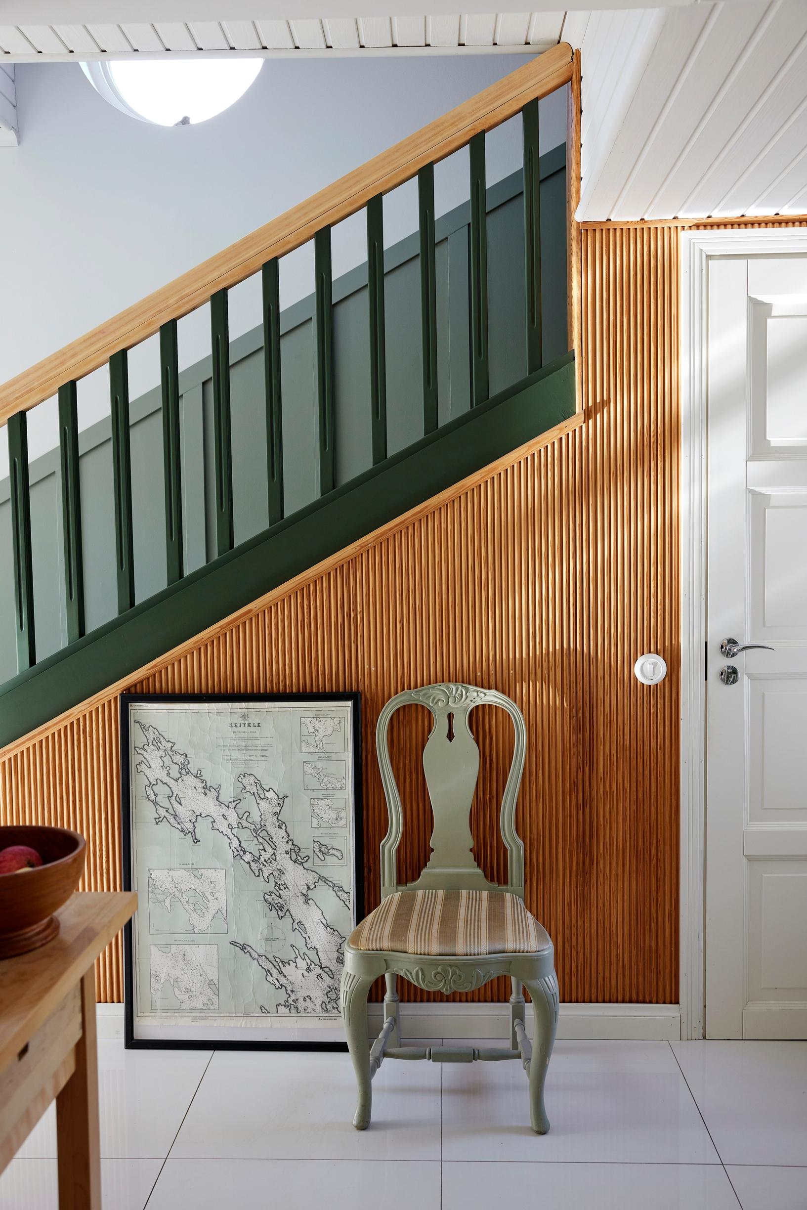 A staircase with a green banister