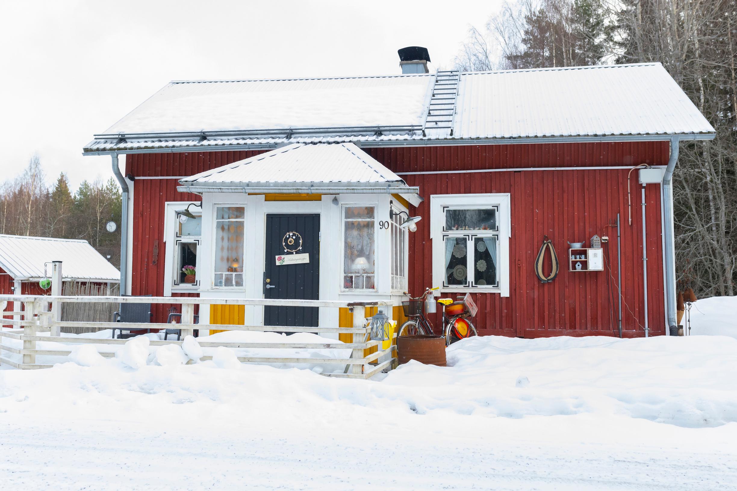 an old red house in the middle of a snowy field