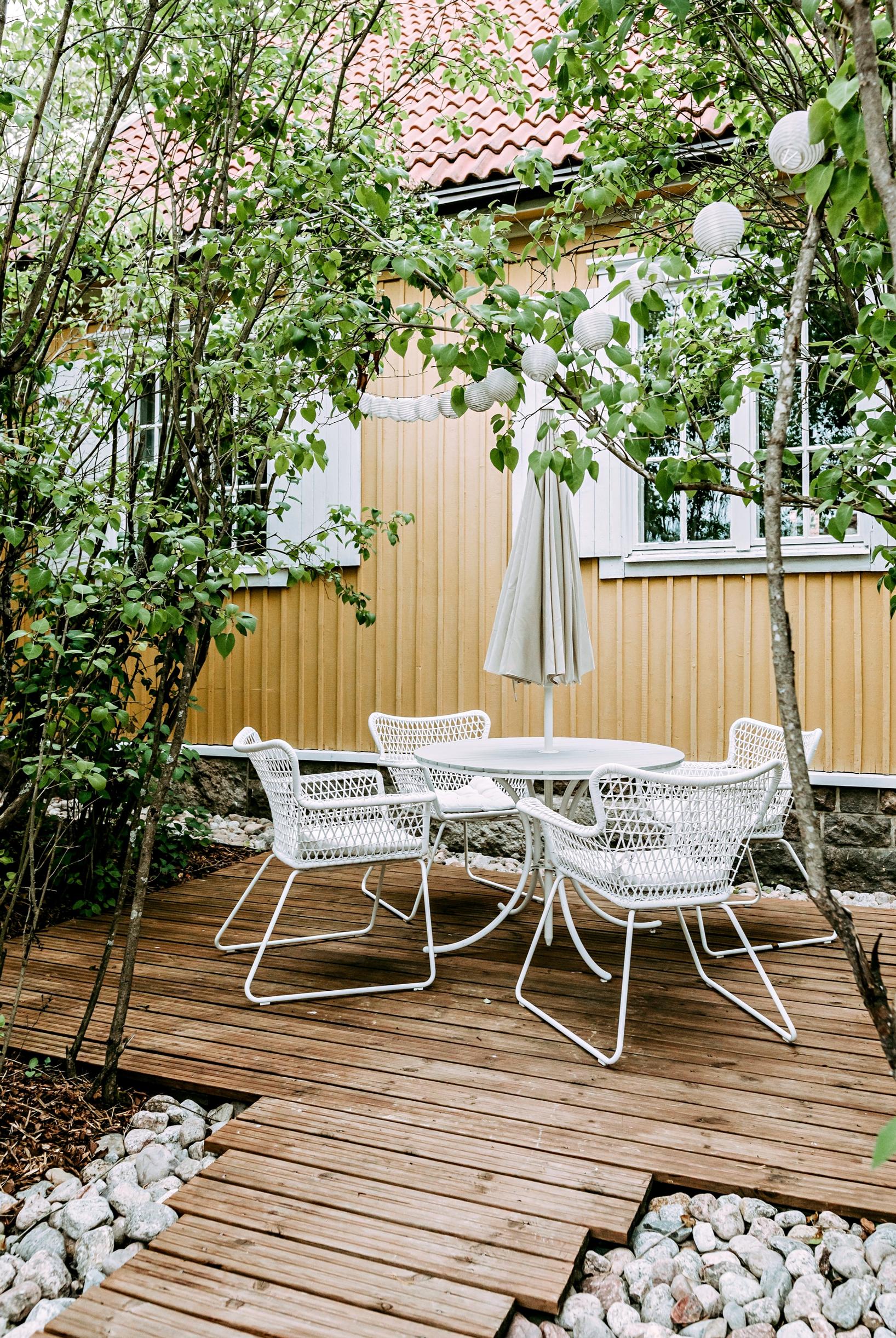 A patio adjacent to a wooden house.