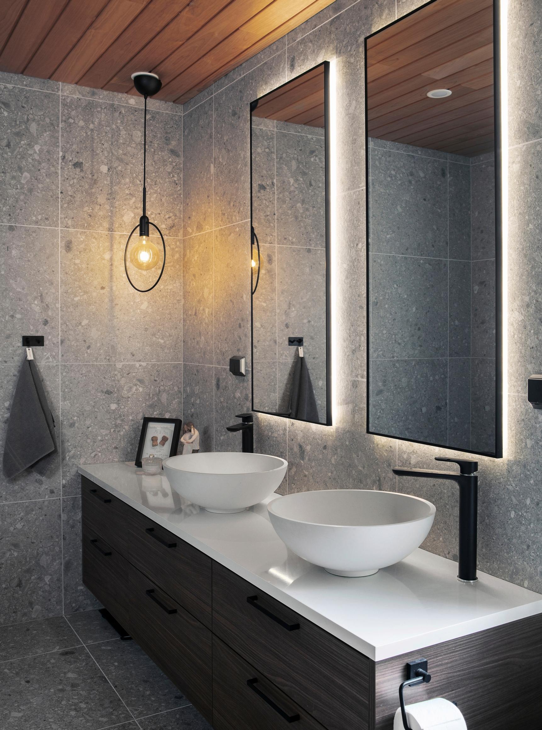 Gray terrazzo tiles and dark wood vanity in the bathroom