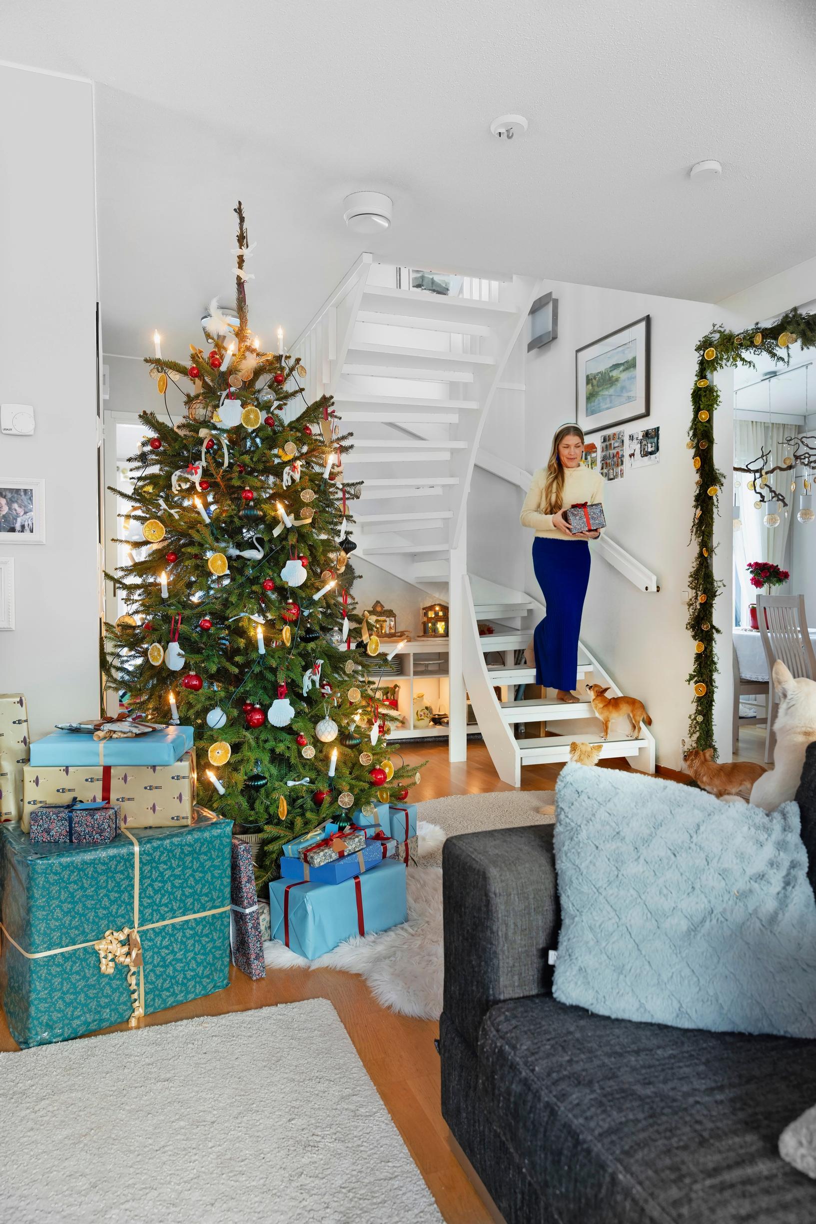 The Huttunen family’s living room, a Christmas tree decorated with dried orange slices. Presents in shades of blue and turquoise.