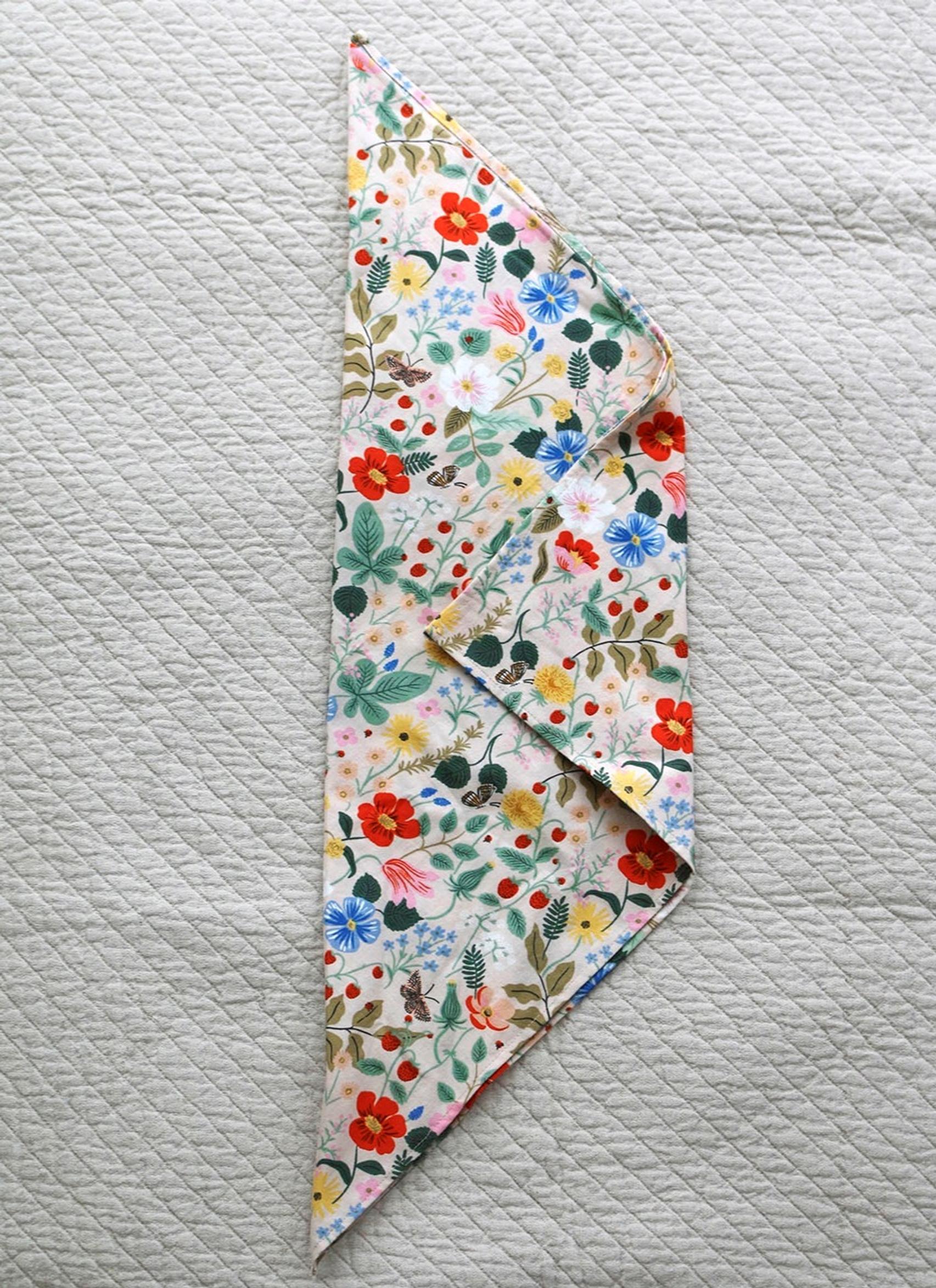 Fold the straight corner of the napkin inward, slightly past the halfway point.