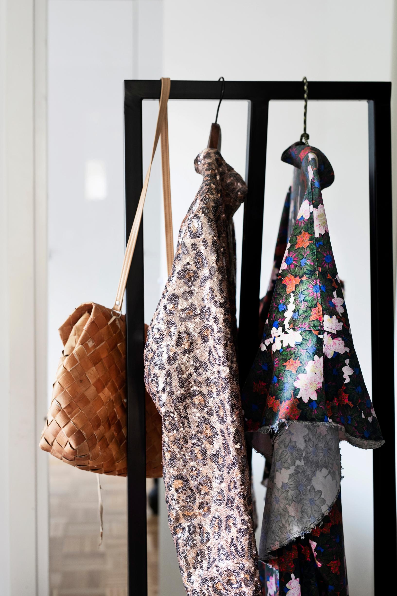clothes on a rack and a bag made of birch bark