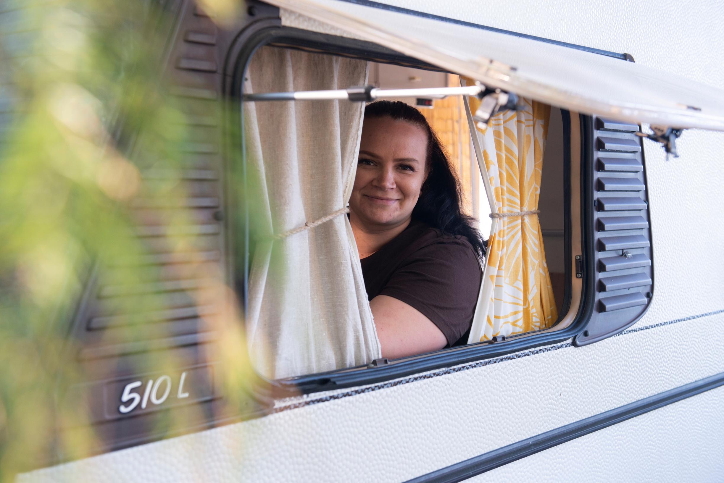 woman looking out of a travel trailer window