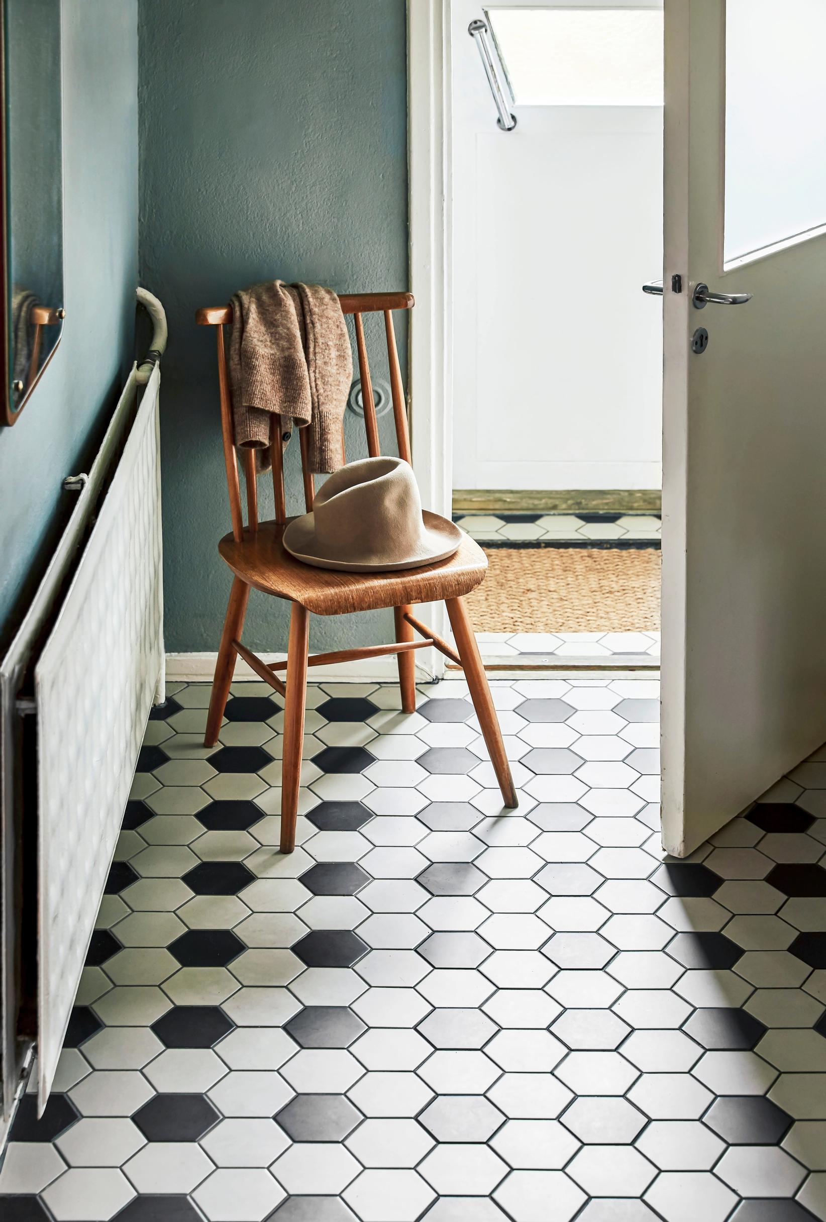Black and white honeycomb-patterned tile floor and a wooden spindle-back chair