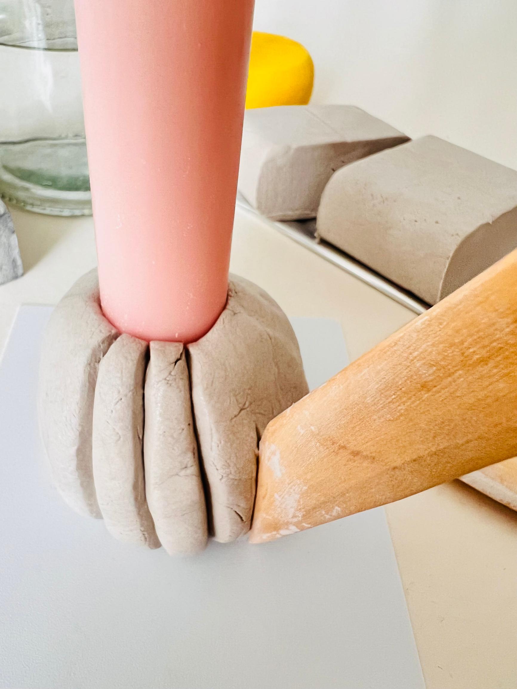 Patterning the clay with a wooden knife.