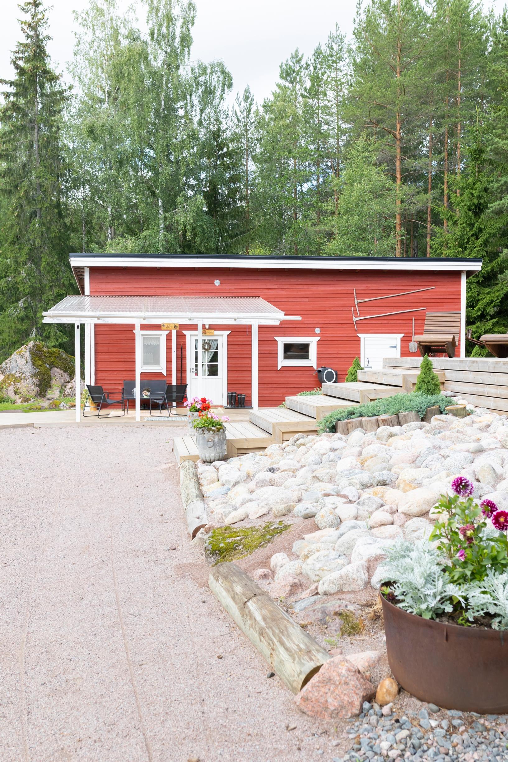 Red-and-white building, large gravel yard, steps leading to the terrace, and stone paving