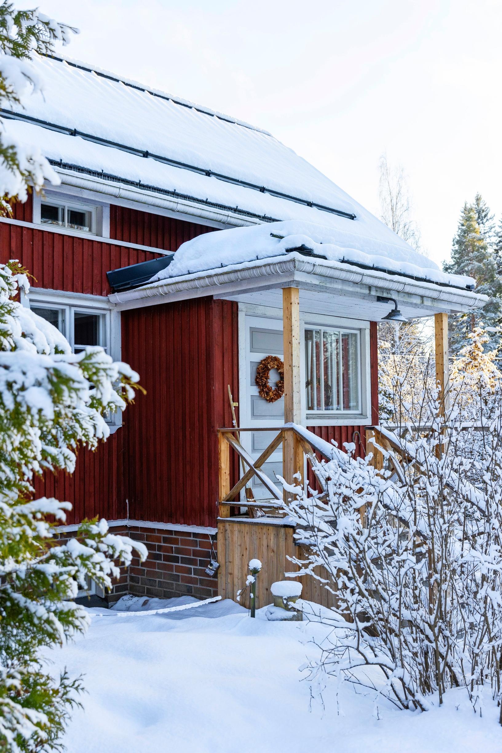Exterior view of the red log house.