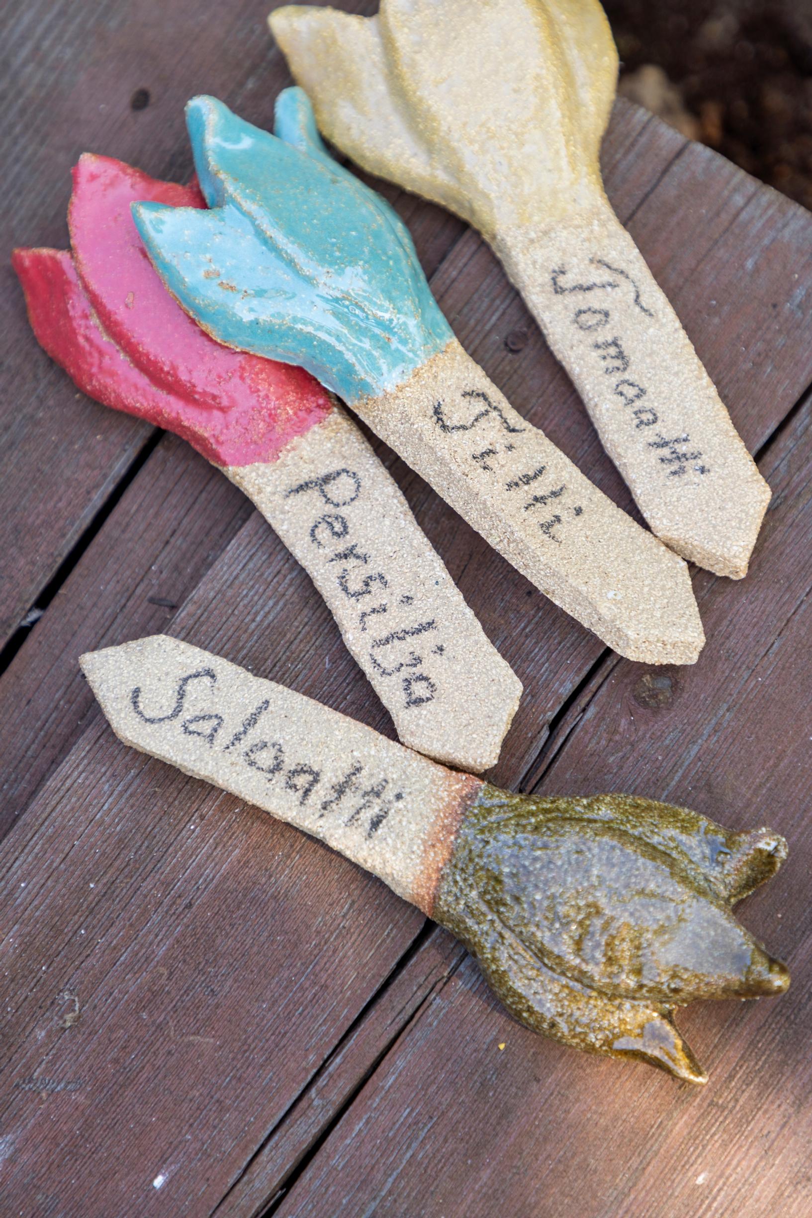 Ceramic labels for herbs on a wooden deck