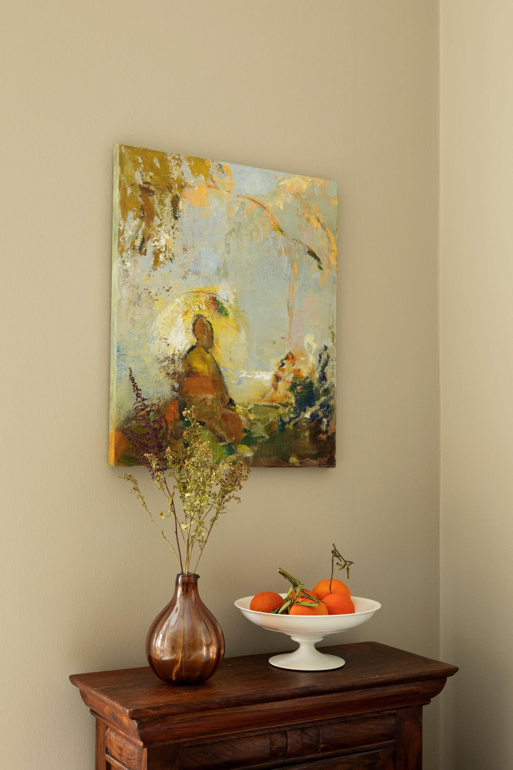 a colorful painting, flowers in a vase, and fruit in a bowl on a dresser