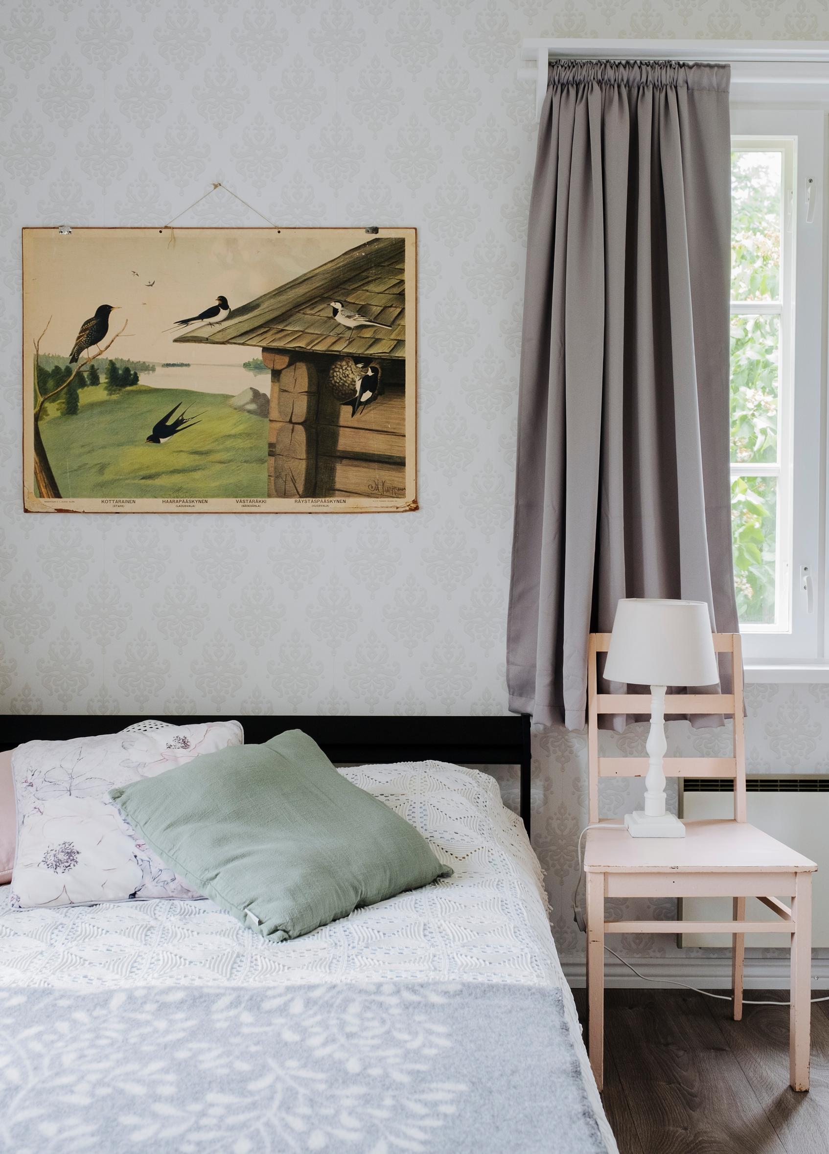 bedroom with a painting, a chair, a double bed, a lamp, and curtains