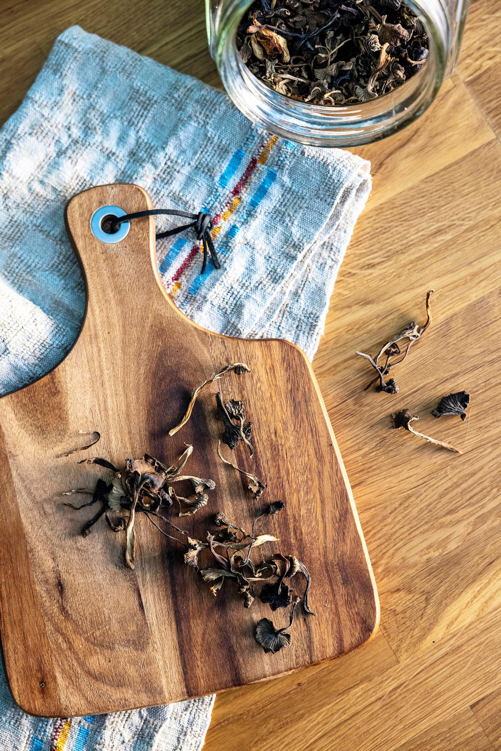 A wooden cutting board on a wooden kitchen countertop.