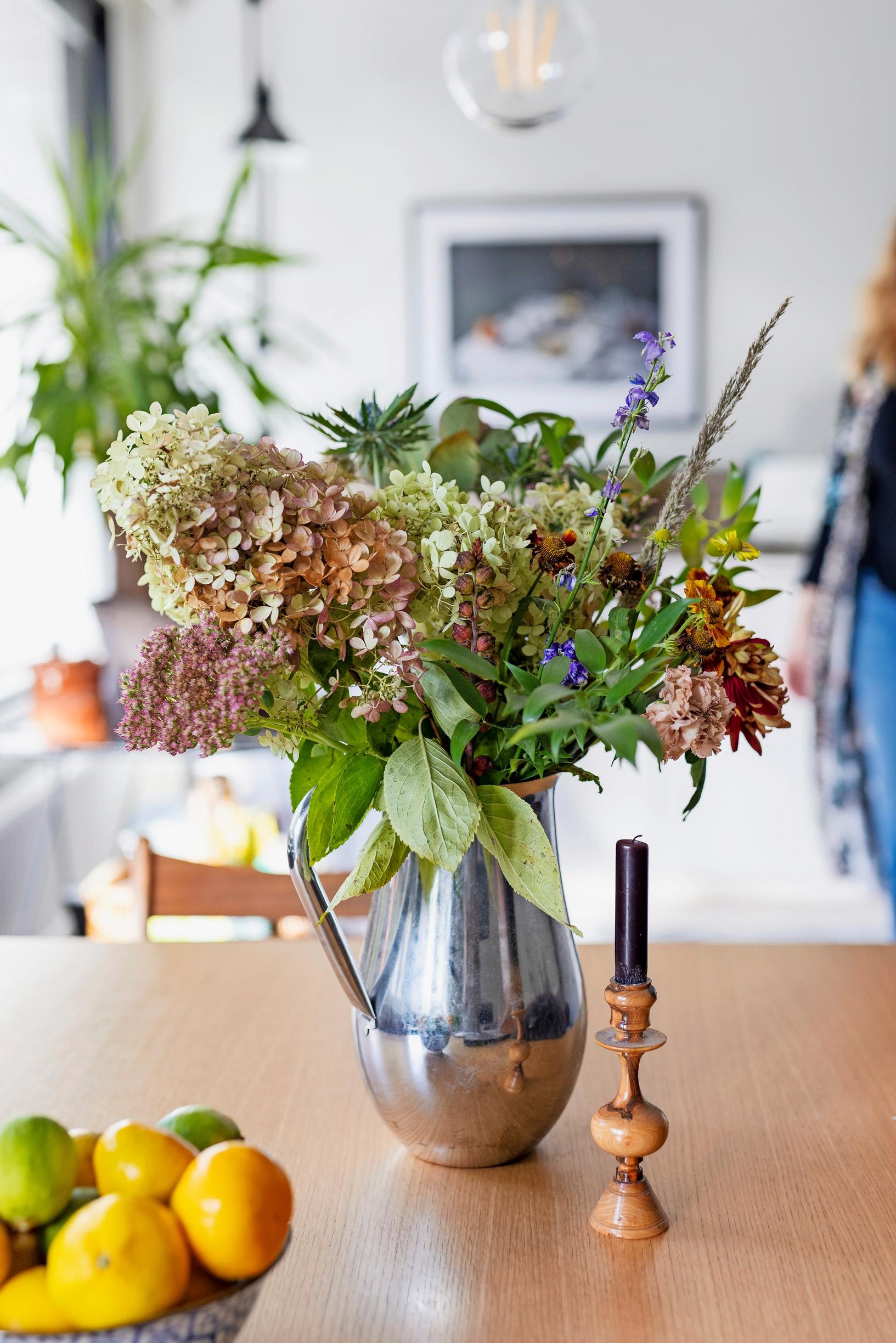 Photo of peegee hydrangeas in a silver pitcher.