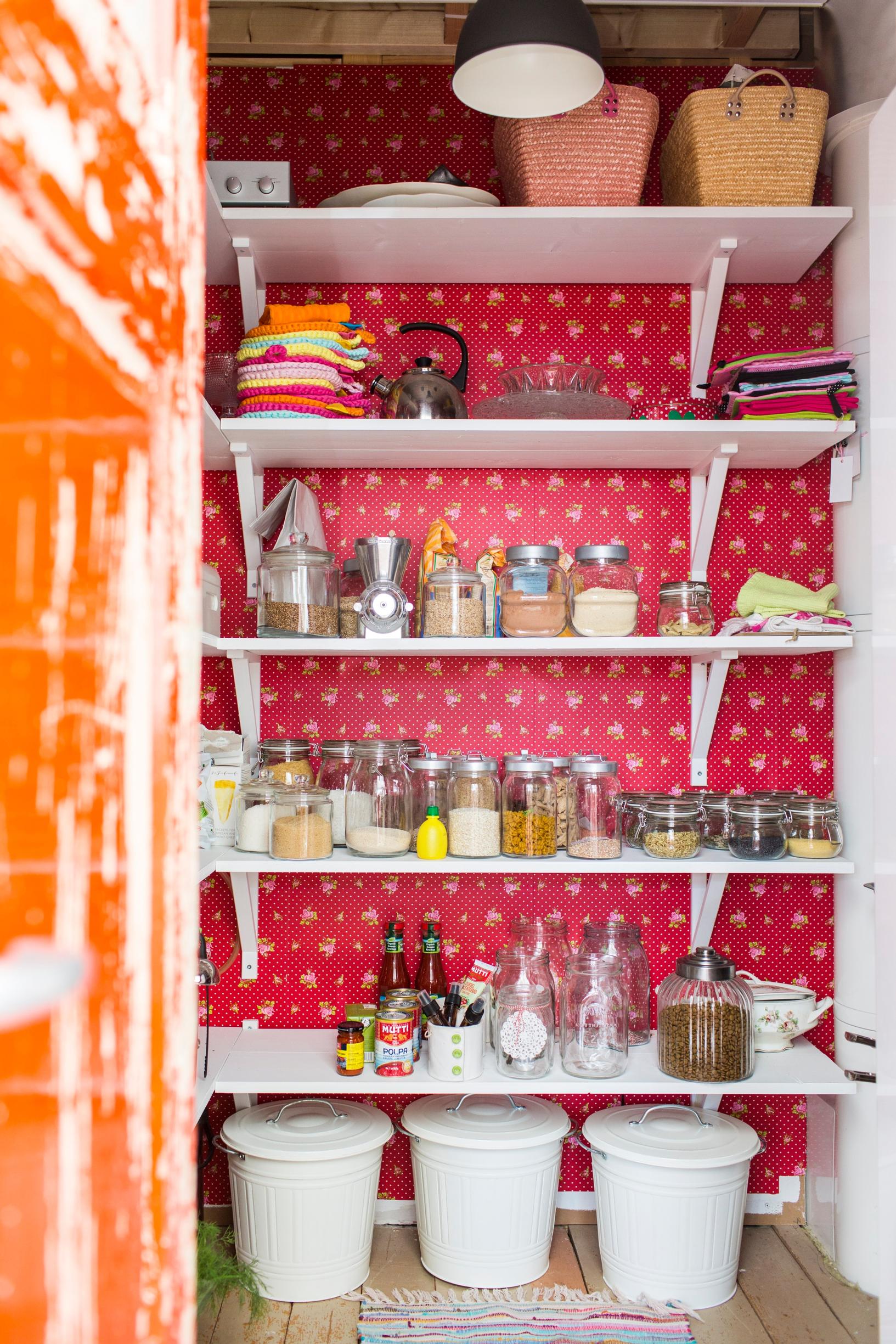 The pantry has been wallpapered, and separate shelves have been attached to the wallpapered wall.