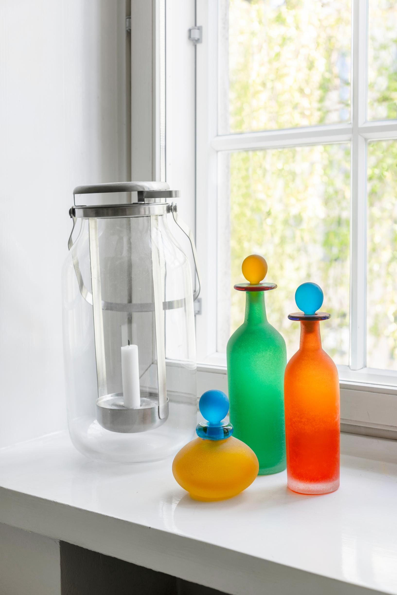 Colorful Murano glass bottles on a windowsill