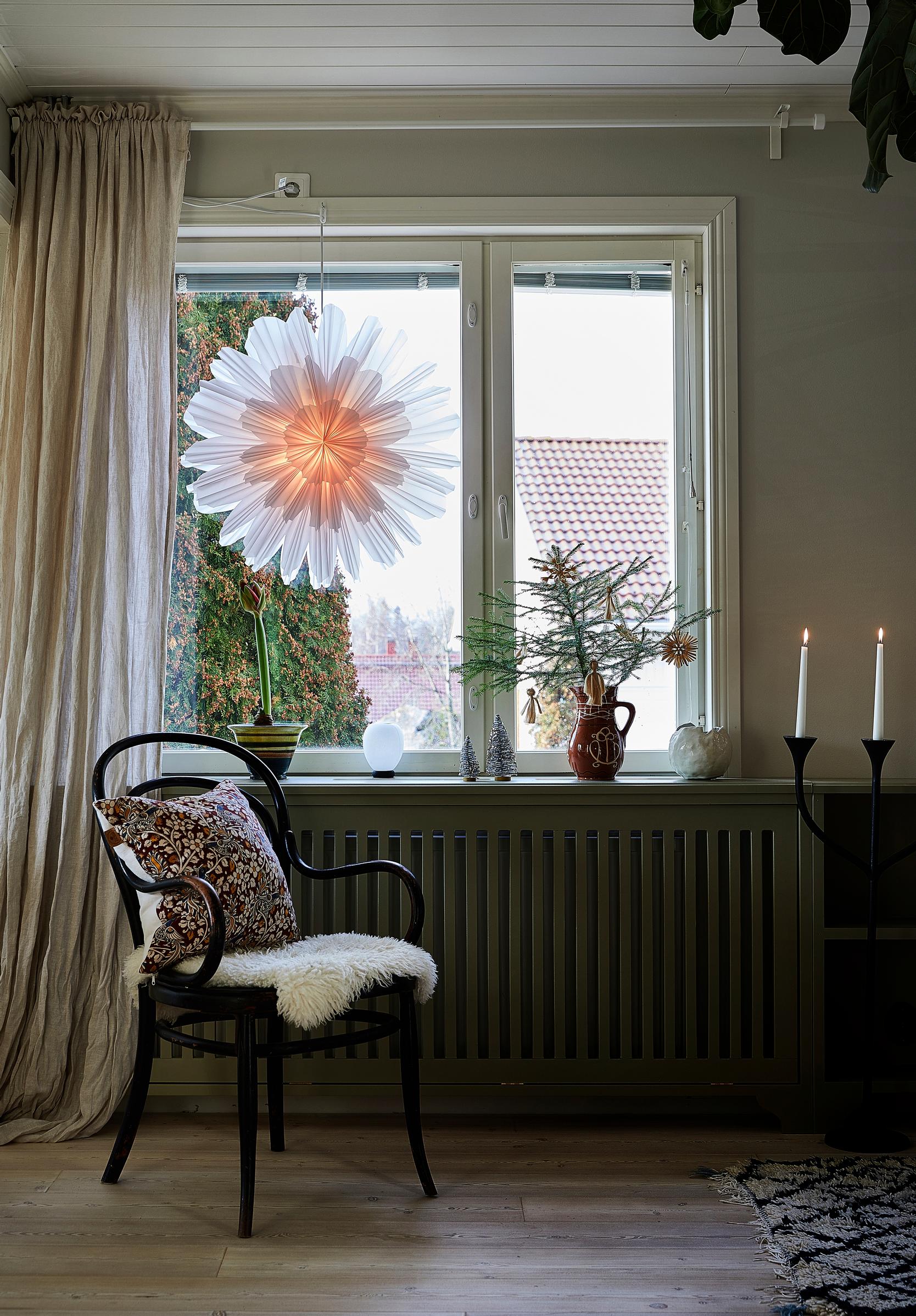 A paper Christmas ornament from Watt & Veke in the window