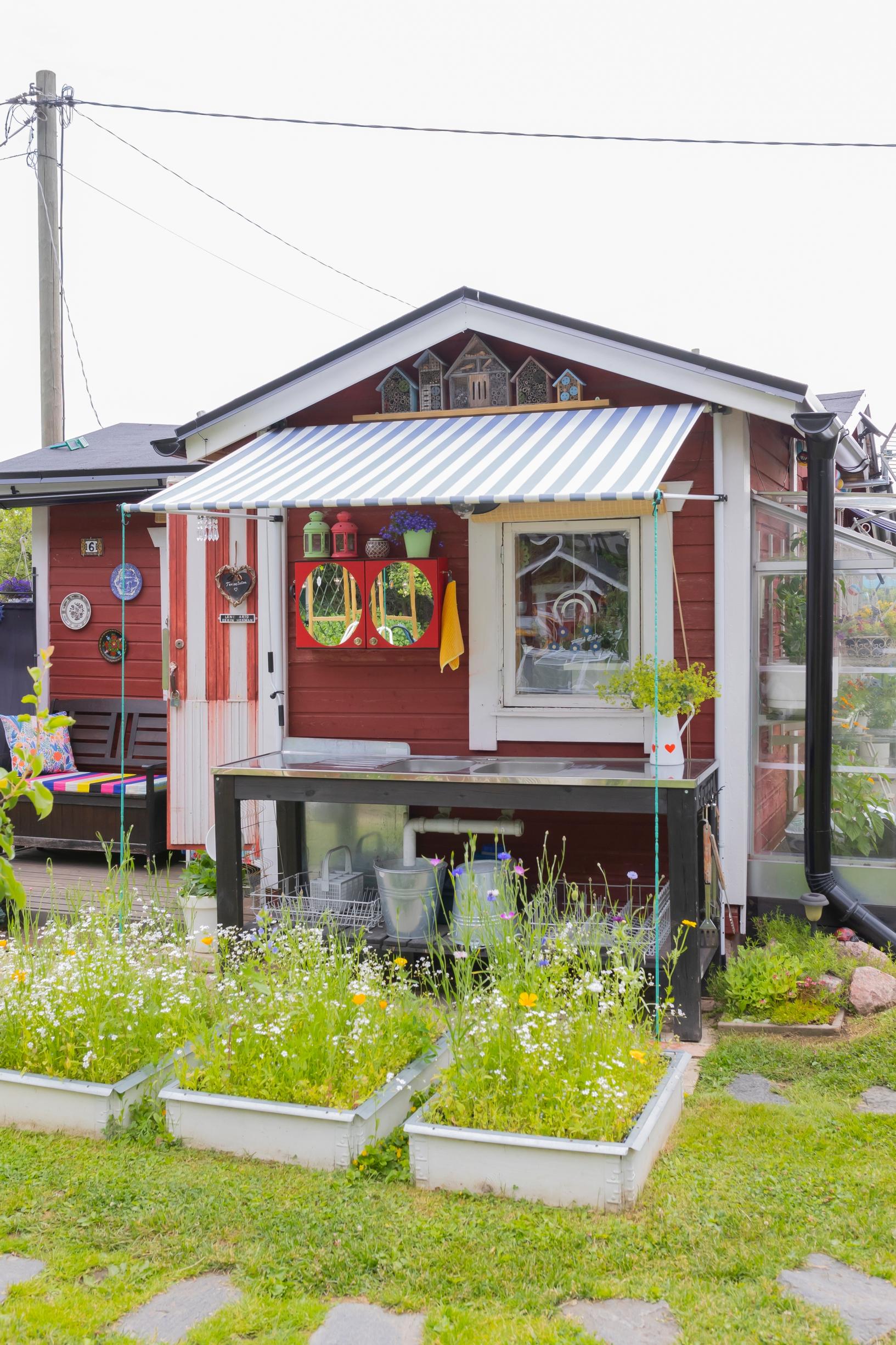 garden beds in boxes in front of the little cottage’s washing station