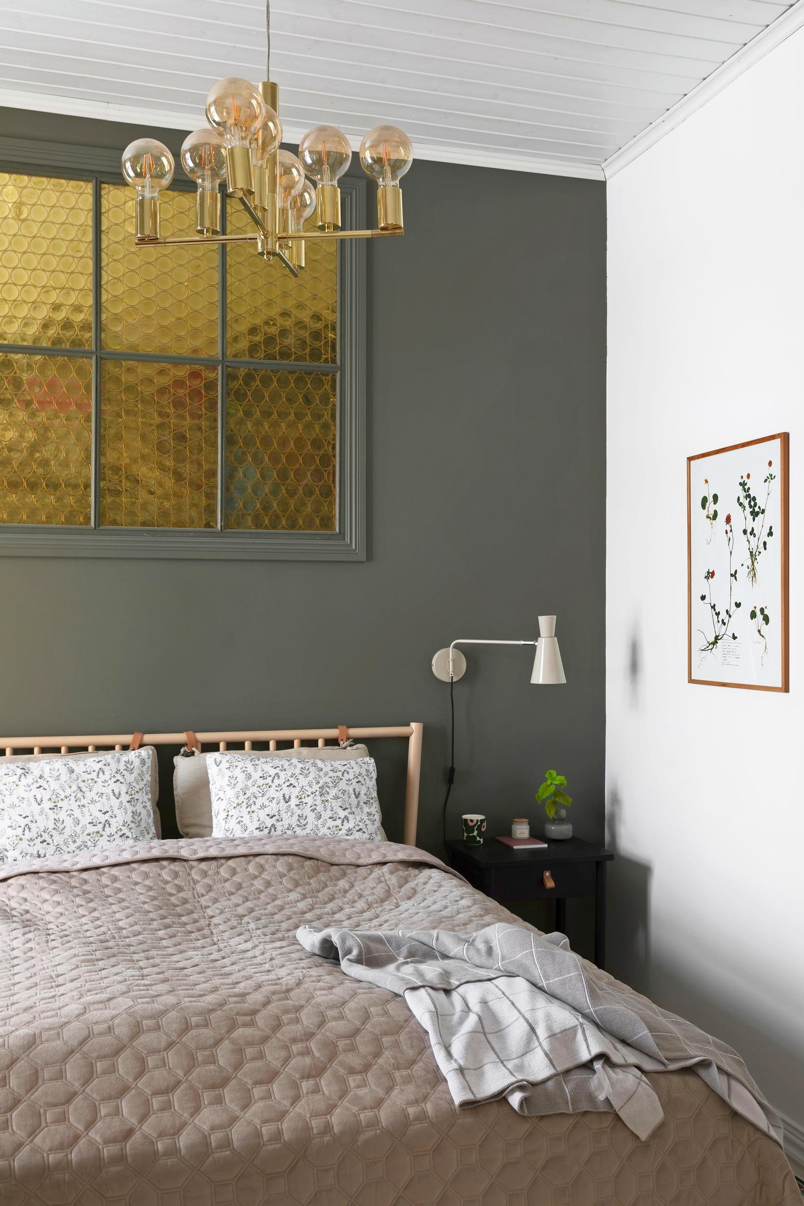 A dark gray interior window with bottle-bottom glass in the bedroom.