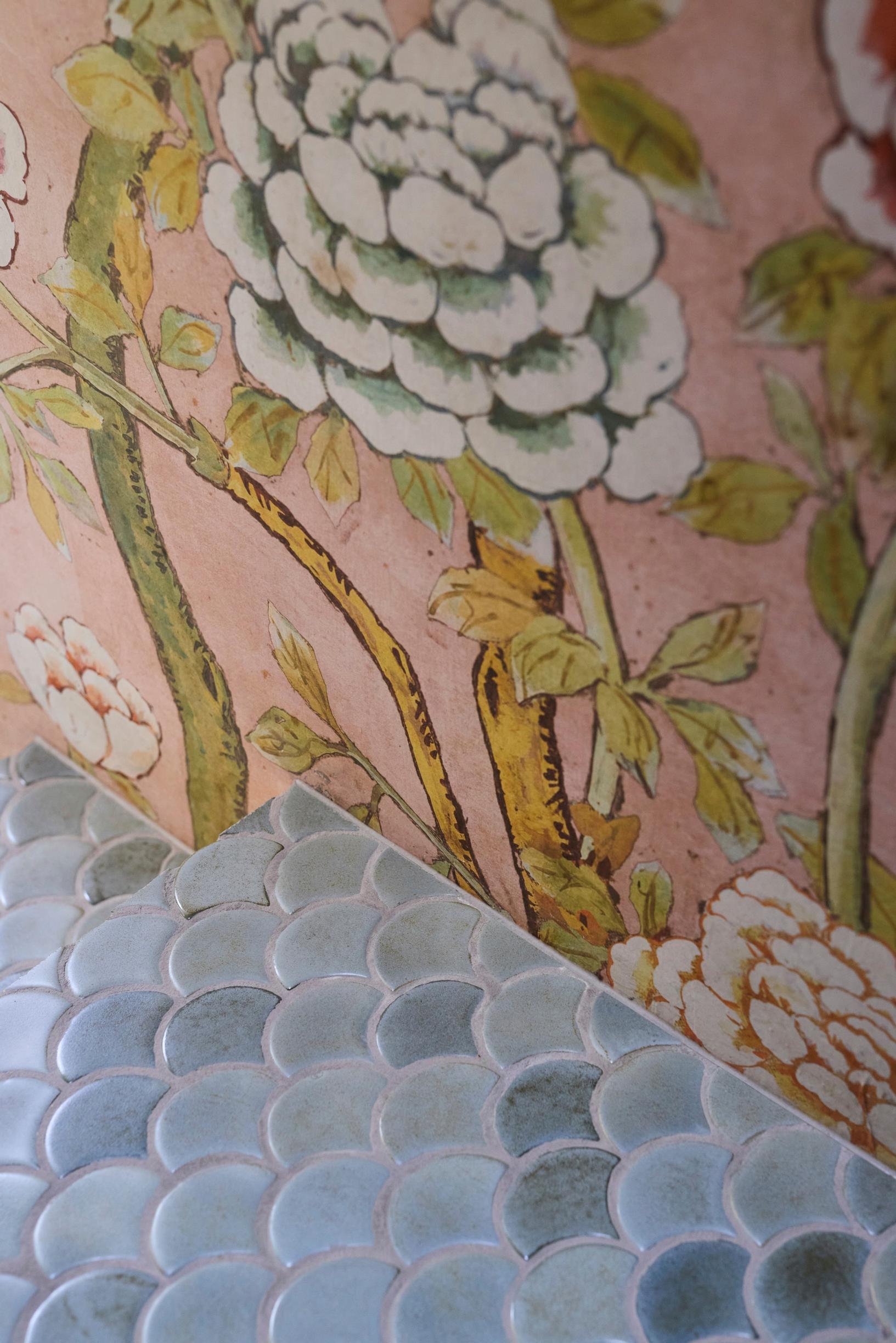 Pink patterned wallpaper and blue fan-shaped tiles on the floor