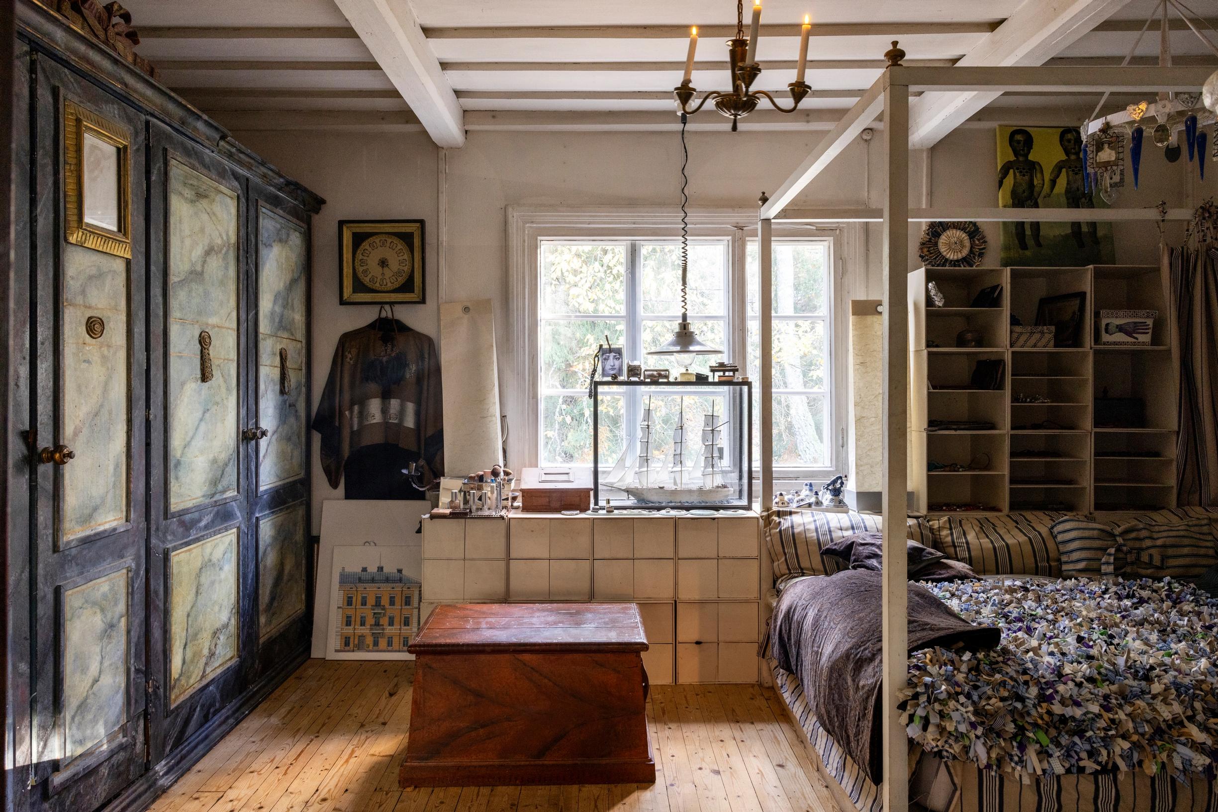 Bedroom with a canopy bed and decoratively painted wardrobes.