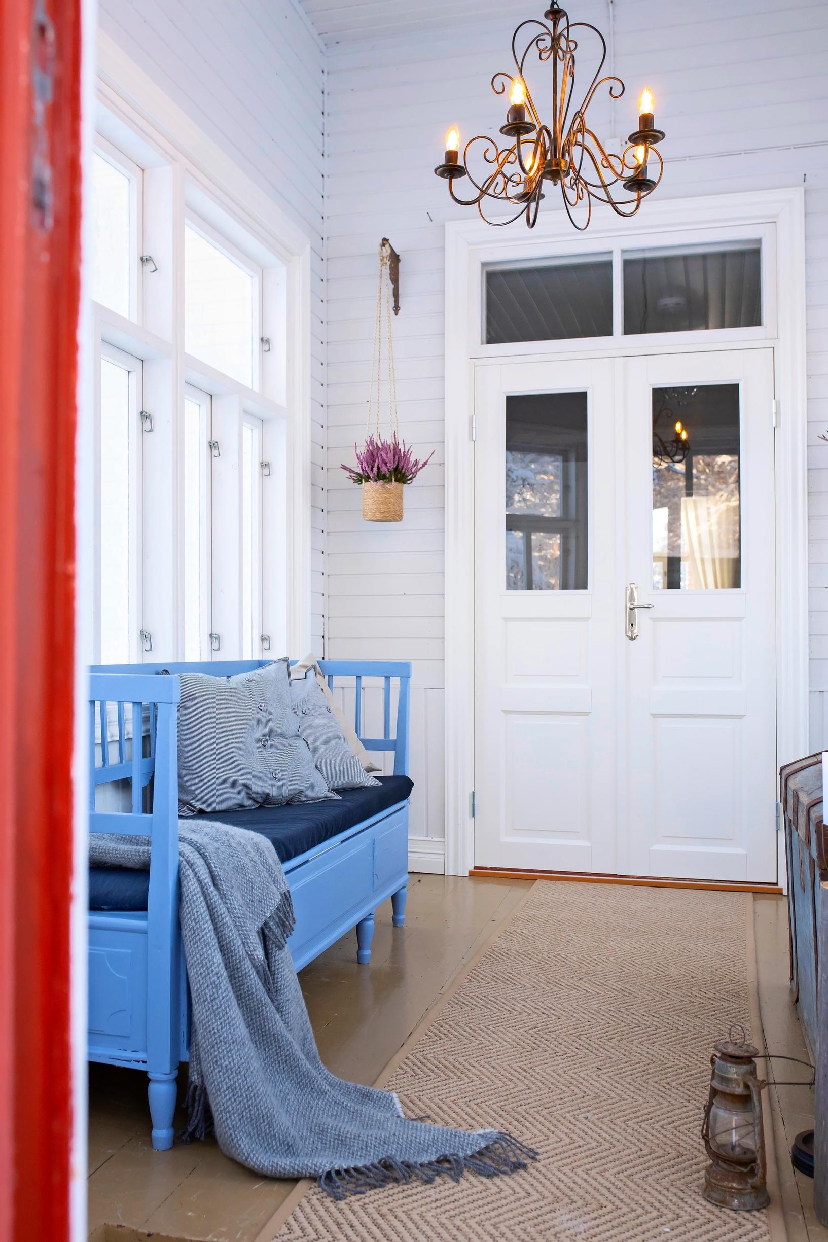 A blue wooden bench on the vicarage’s glass porch