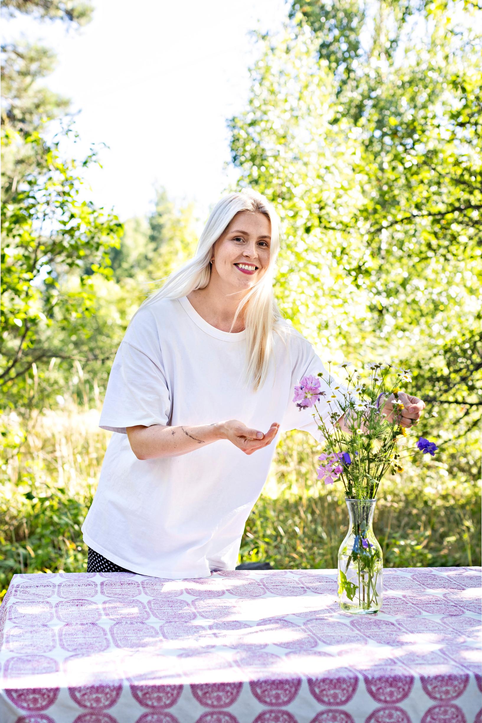 Essi Hellén arranging flowers in a vase