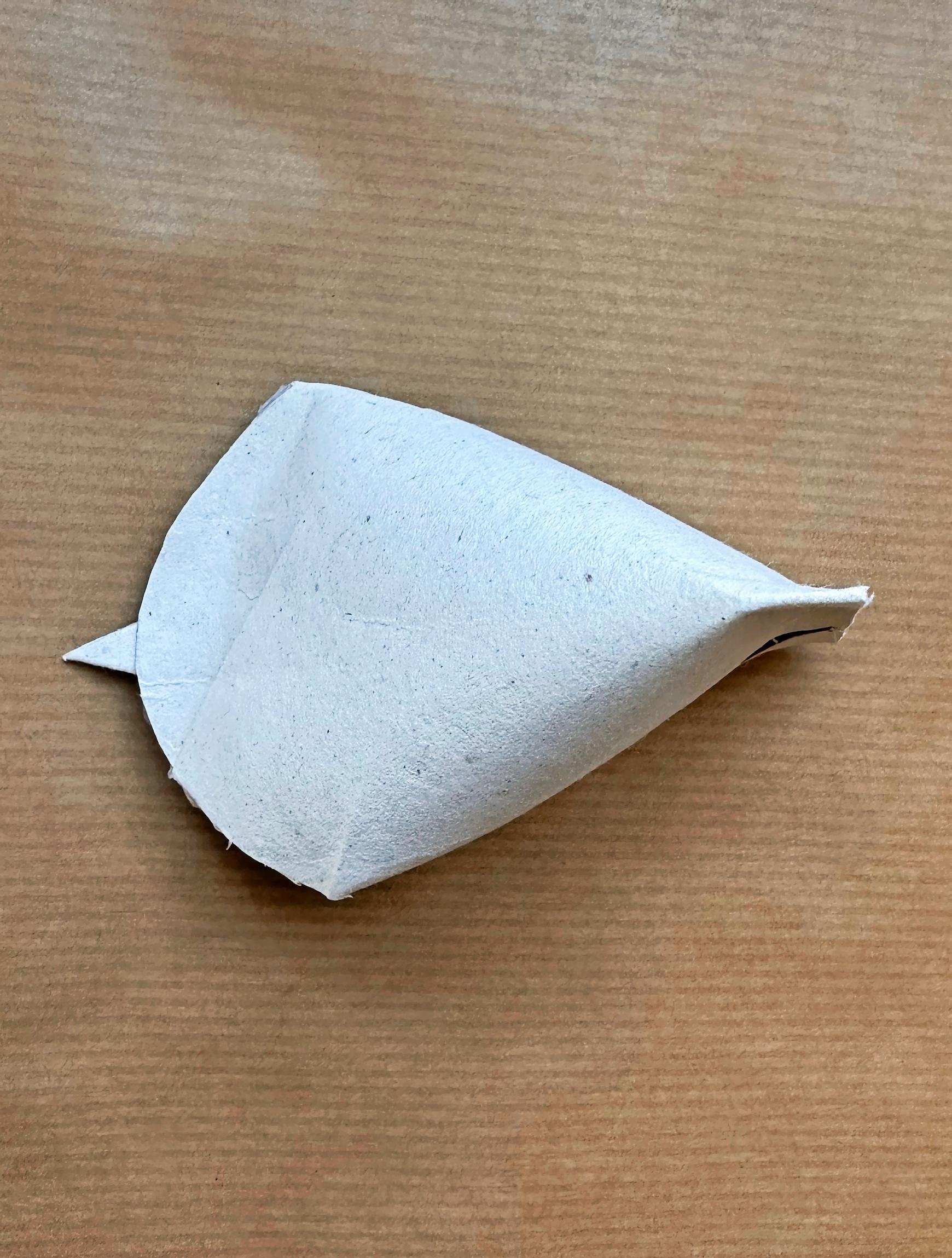 The toilet paper roll has been glued with hot glue to form the shape of a bird.