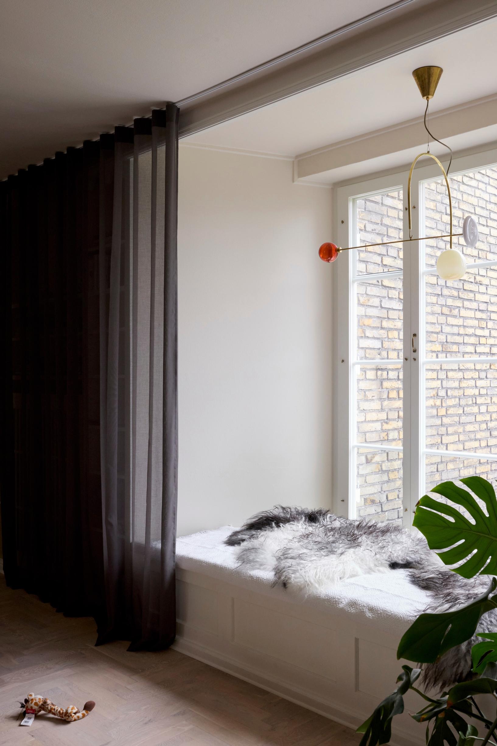 A mouth-blown pendant lamp above the windowsill