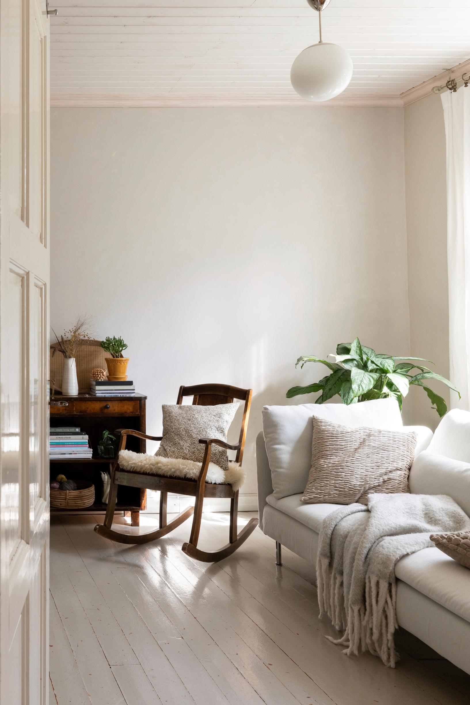 A room decorated with light textiles and old wooden furniture
