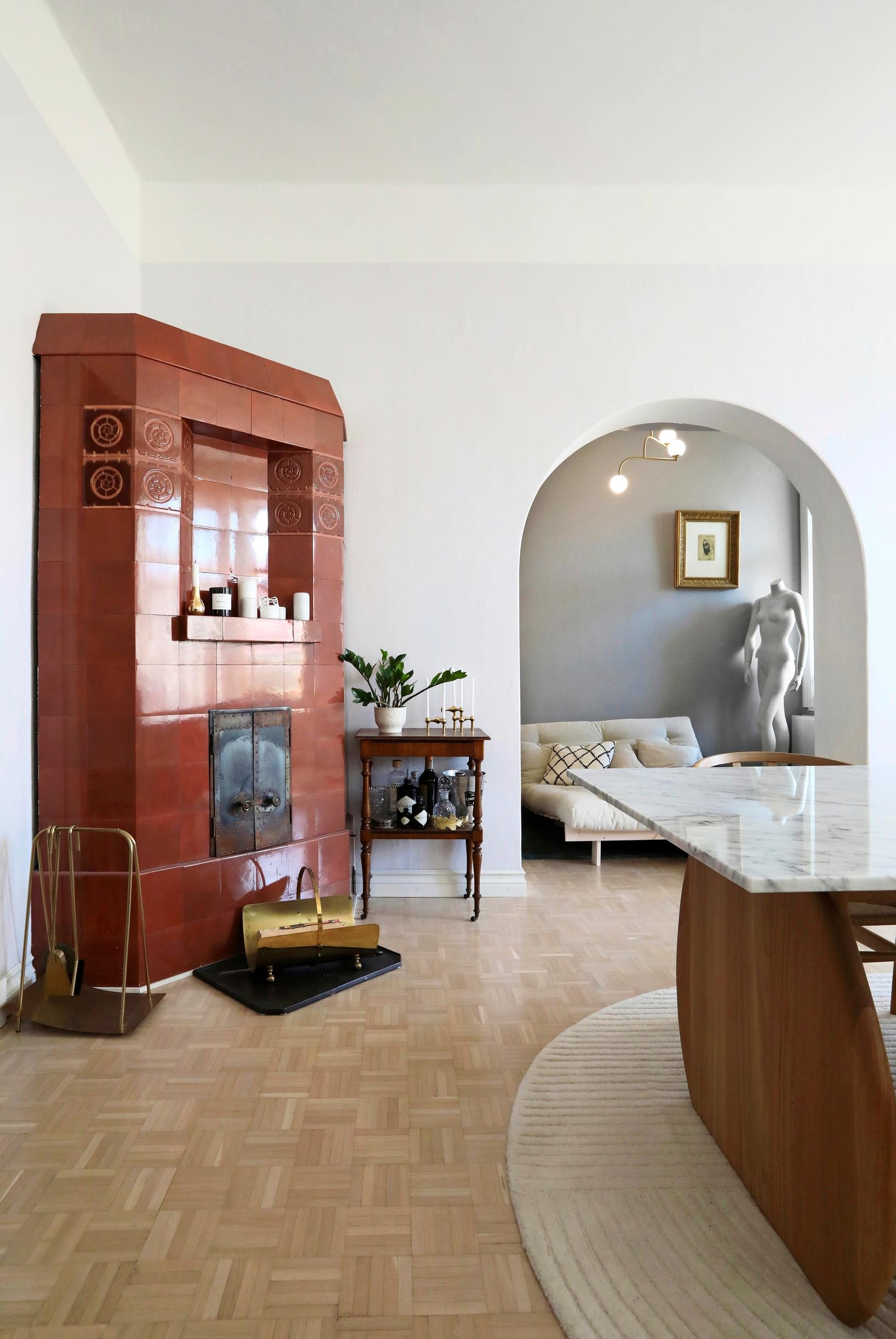 Reddish-brown tiled stove and an arched doorway