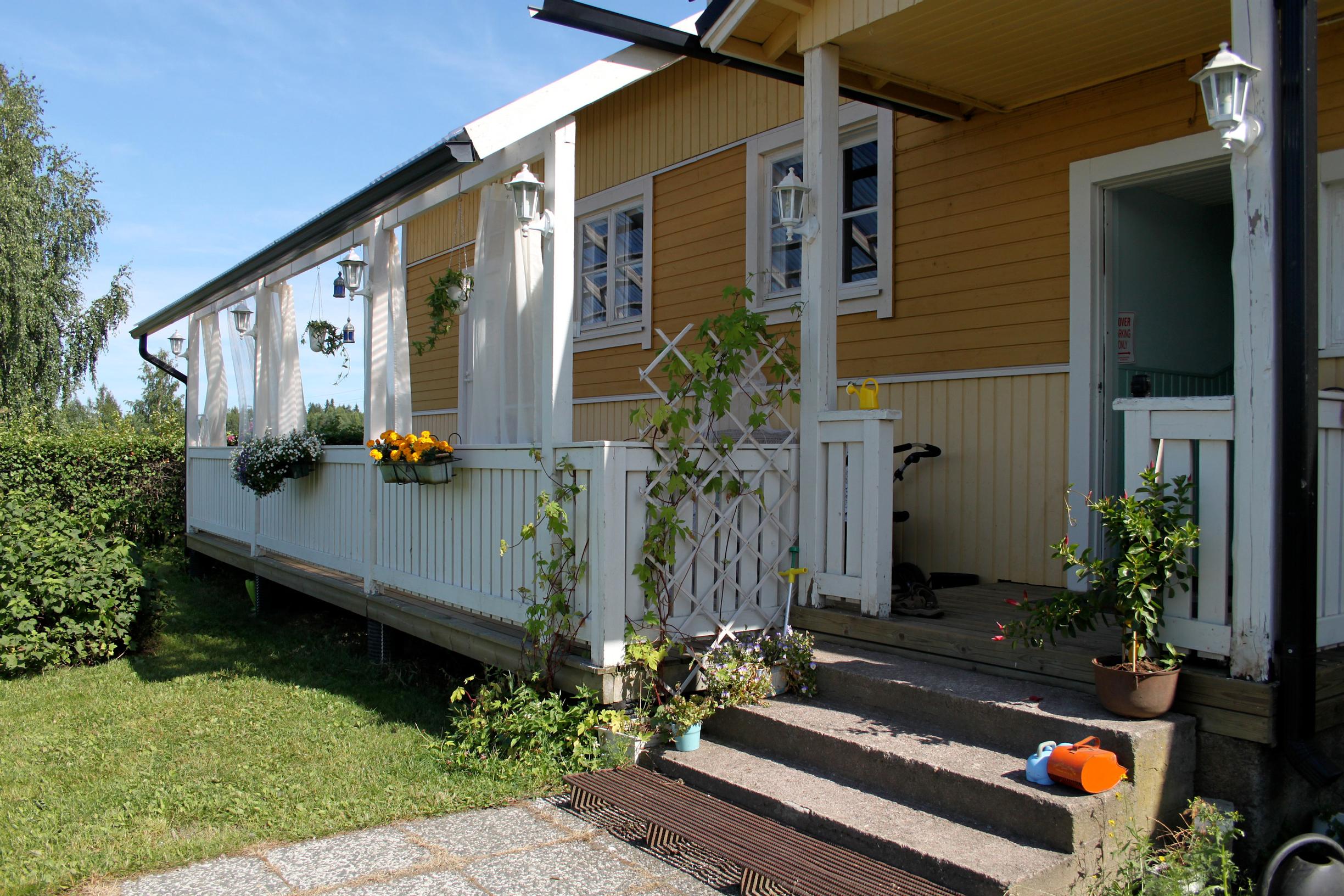 A fenced-in deck in front of the wooden single-family home