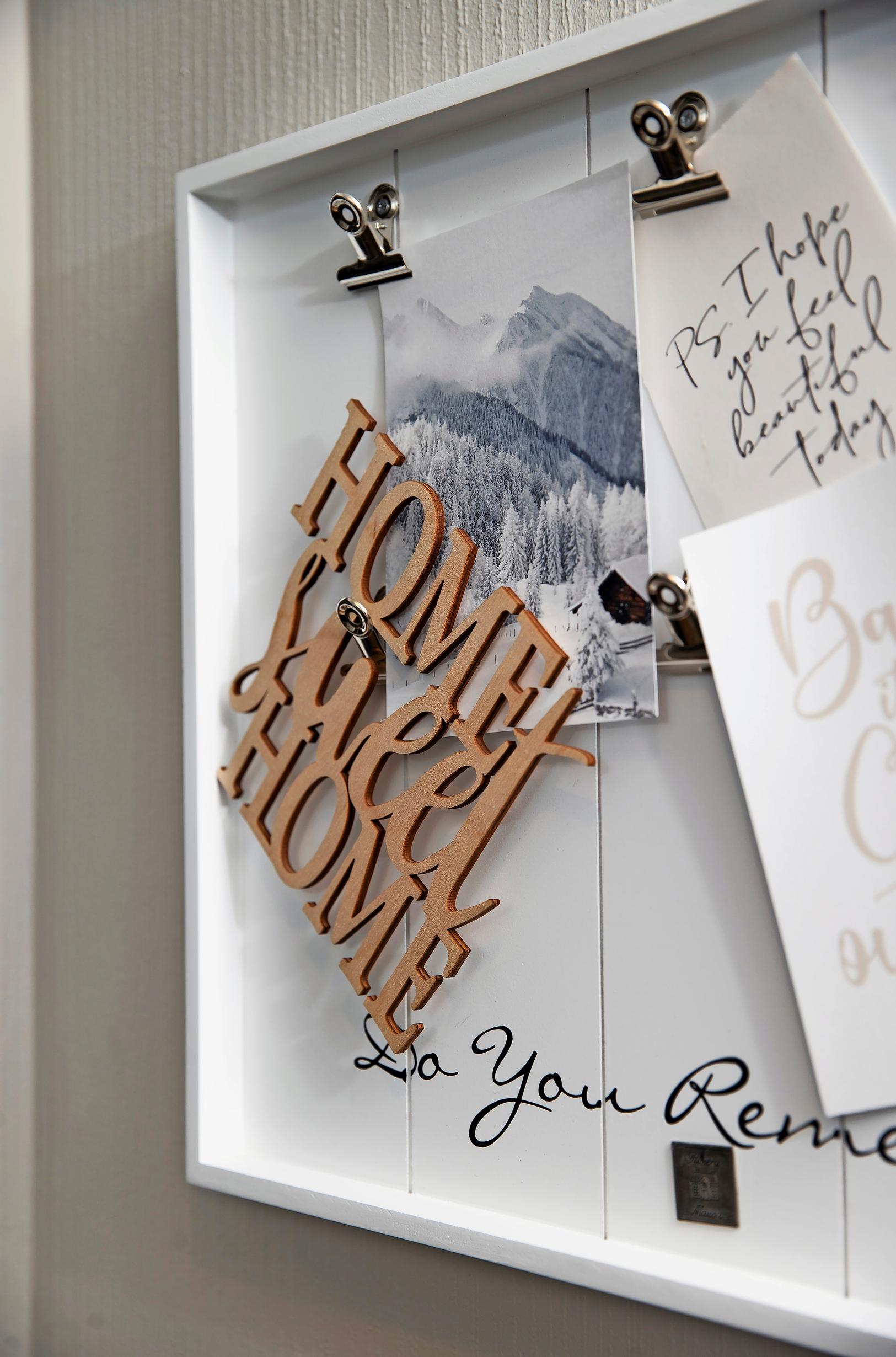 a frame displaying postcards and the text “Home sweet home.”