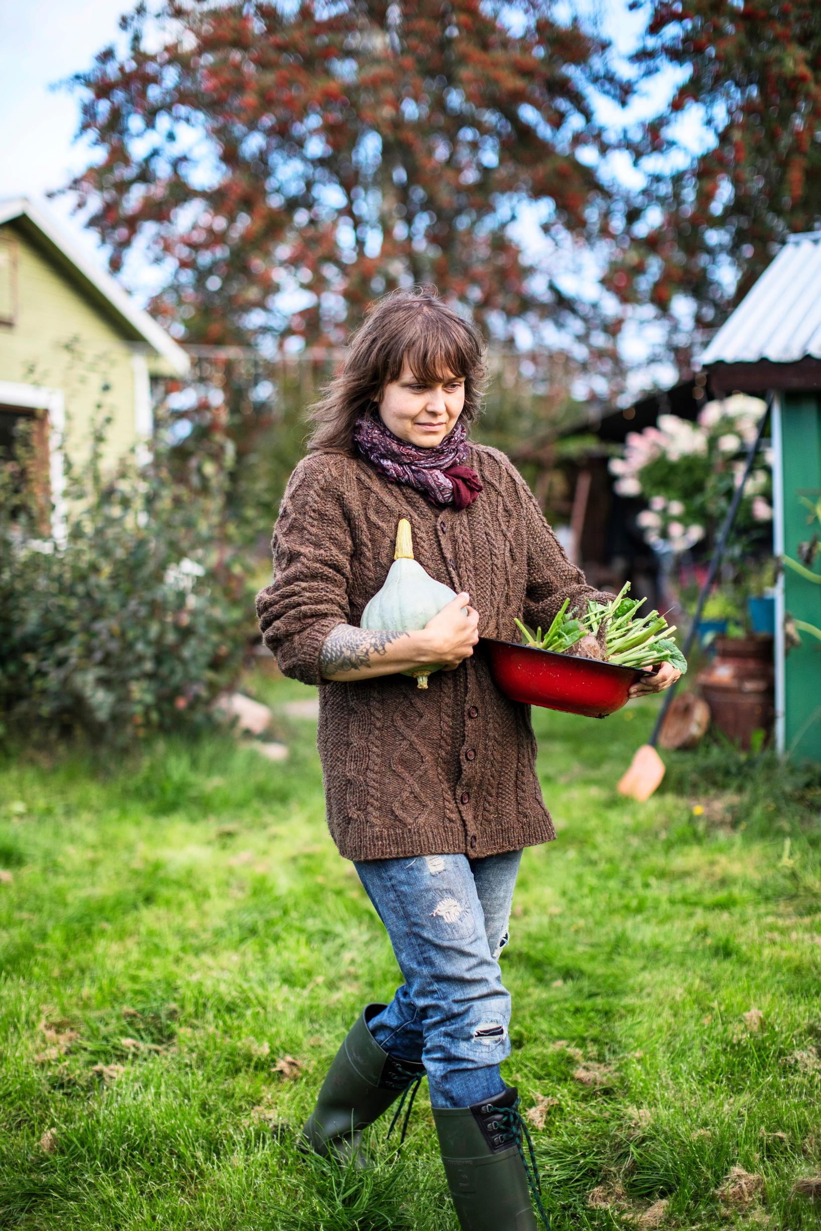 Stella Karlsson carrying her vegetable garden harvest in her garden